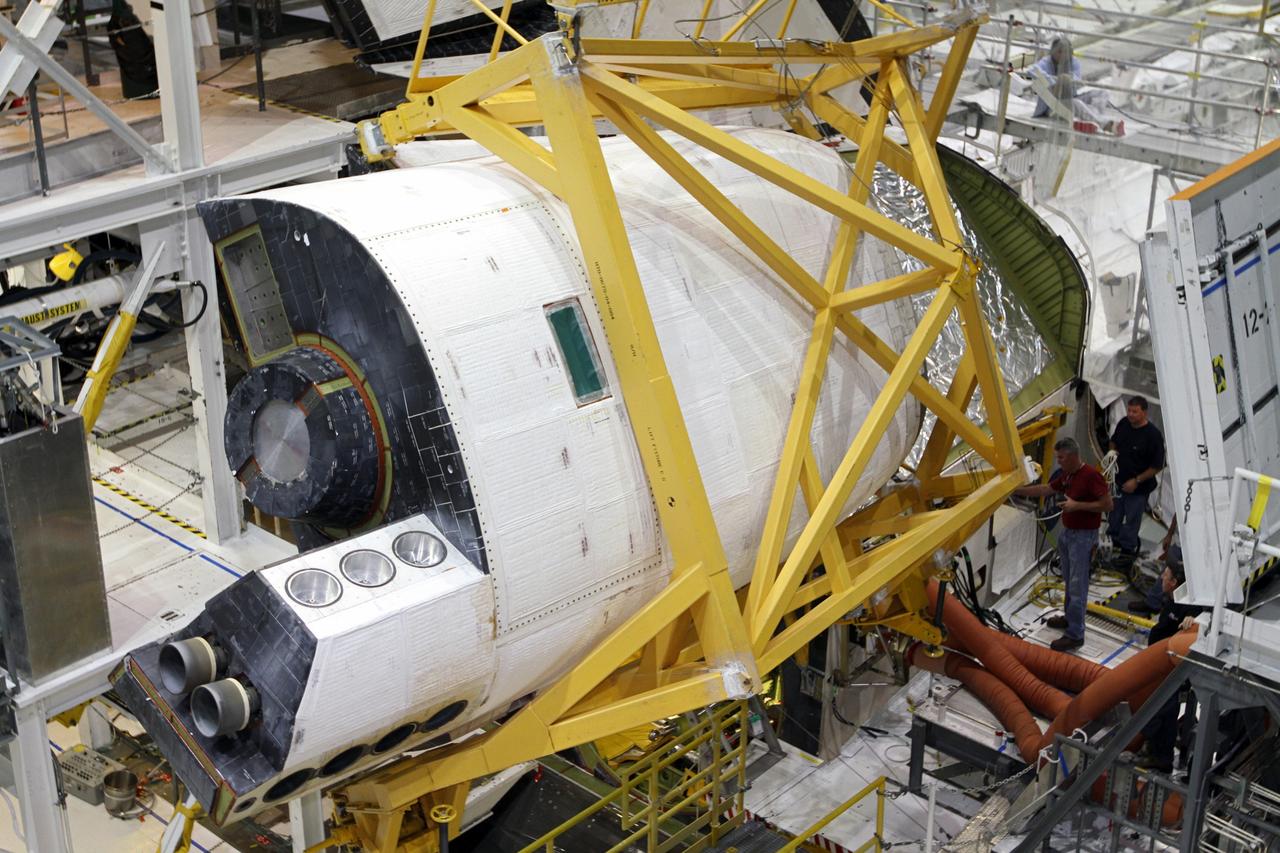 CAPE CANAVERAL, Fla. – In Orbiter Processing Facility-2 at NASA’s Kennedy Space Center in Florida, a large crane moves the right orbital maneuvering system OMS pod closer to space shuttle Endeavour for installation. The OMS pod underwent complete deservicing and cleaning at White Sands Space Harbor in New Mexico, part of the transition and retirement processing of each shuttle. Endeavour is being prepared for public display at the California Science Center in Los Angeles. Over the course of its 19-year career, Endeavour spent 299 days in space during 25 missions. For more information, visit http://www.nasa.gov/shuttle. Photo credit: NASA/Kim Shiflett