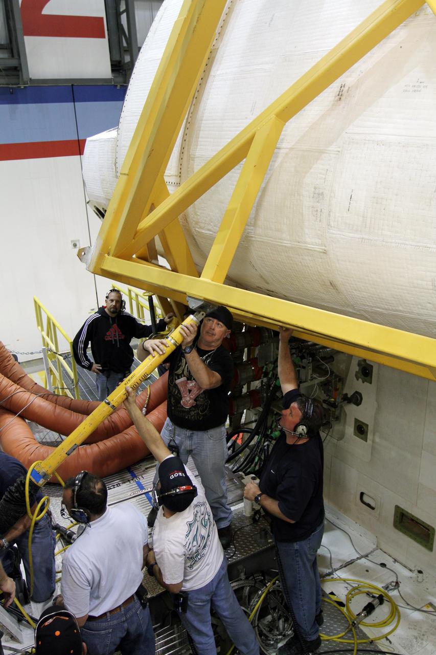 CAPE CANAVERAL, Fla. – In Orbiter Processing Facility-2 at NASA’s Kennedy Space Center in Florida, United Space Alliance technicians assist with removal of the large crane that was used to lift and move the right orbital maneuvering system OMS pod for installation on space shuttle Endeavour. The OMS pod underwent complete deservicing and cleaning at White Sands Space Harbor in New Mexico, part of the transition and retirement processing of each shuttle. Endeavour is being prepared for public display at the California Science Center in Los Angeles. Over the course of its 19-year career, Endeavour spent 299 days in space during 25 missions. For more information, visit http://www.nasa.gov/shuttle. Photo credit: NASA/Kim Shiflett