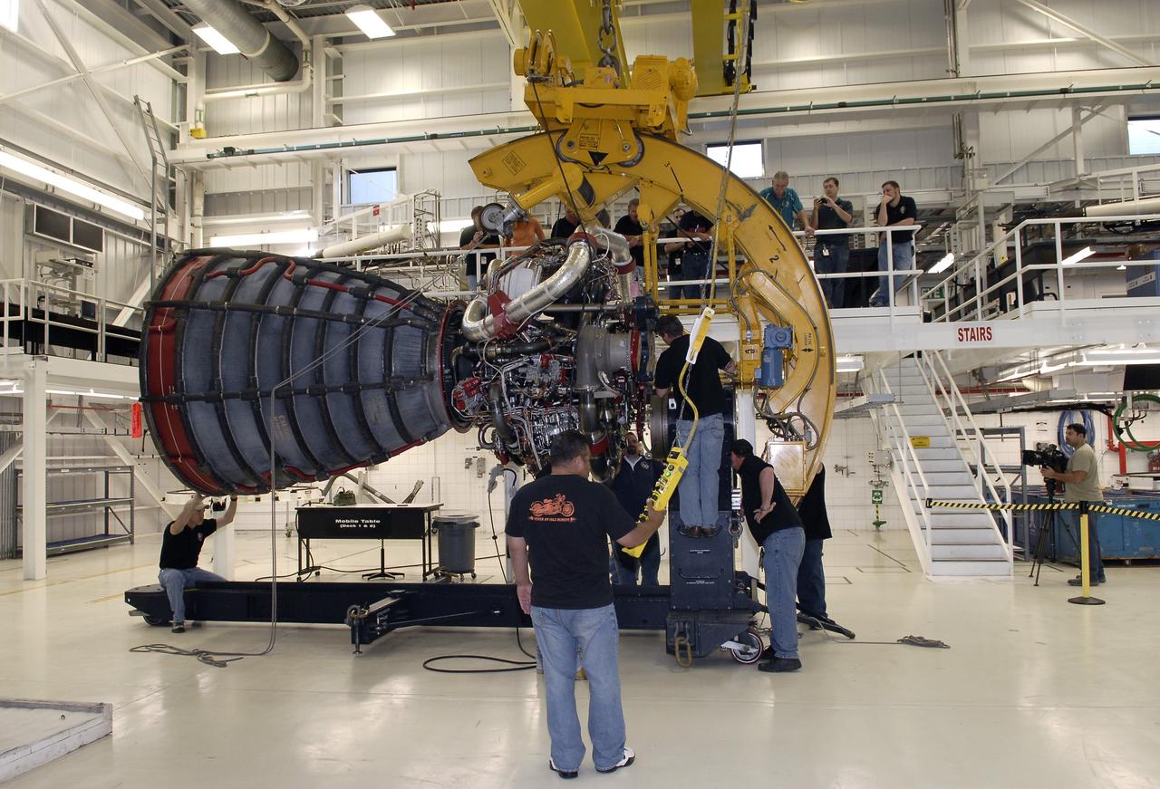 CAPE CANAVERAL, Fla. – Technicians lower a Pratt and Whitney Rocketdyne space shuttle main engine, or SSME, onto a portable workstand inside the SSME Processing Facility, the engine shop at NASA’s Kennedy Space Center in Florida.  The engine was rotated into a horizontal position with the aid of an engine-handling device attached to a crane.    The engine is one of the last SSMEs remaining at Kennedy and is being prepared for shipment to NASA's Stennis Space Center in Mississippi. The first two groups of engines were shipped from Kennedy to Stennis in November 2011 and January 2012 the remaining engines are scheduled to depart on April 9.  Altogether, 15 shuttle-era engines will be stored at Stennis for reuse on NASA’s Space Launch System heavy-lift rocket, under development. Photo credit: NASA/Tim Jacobs
