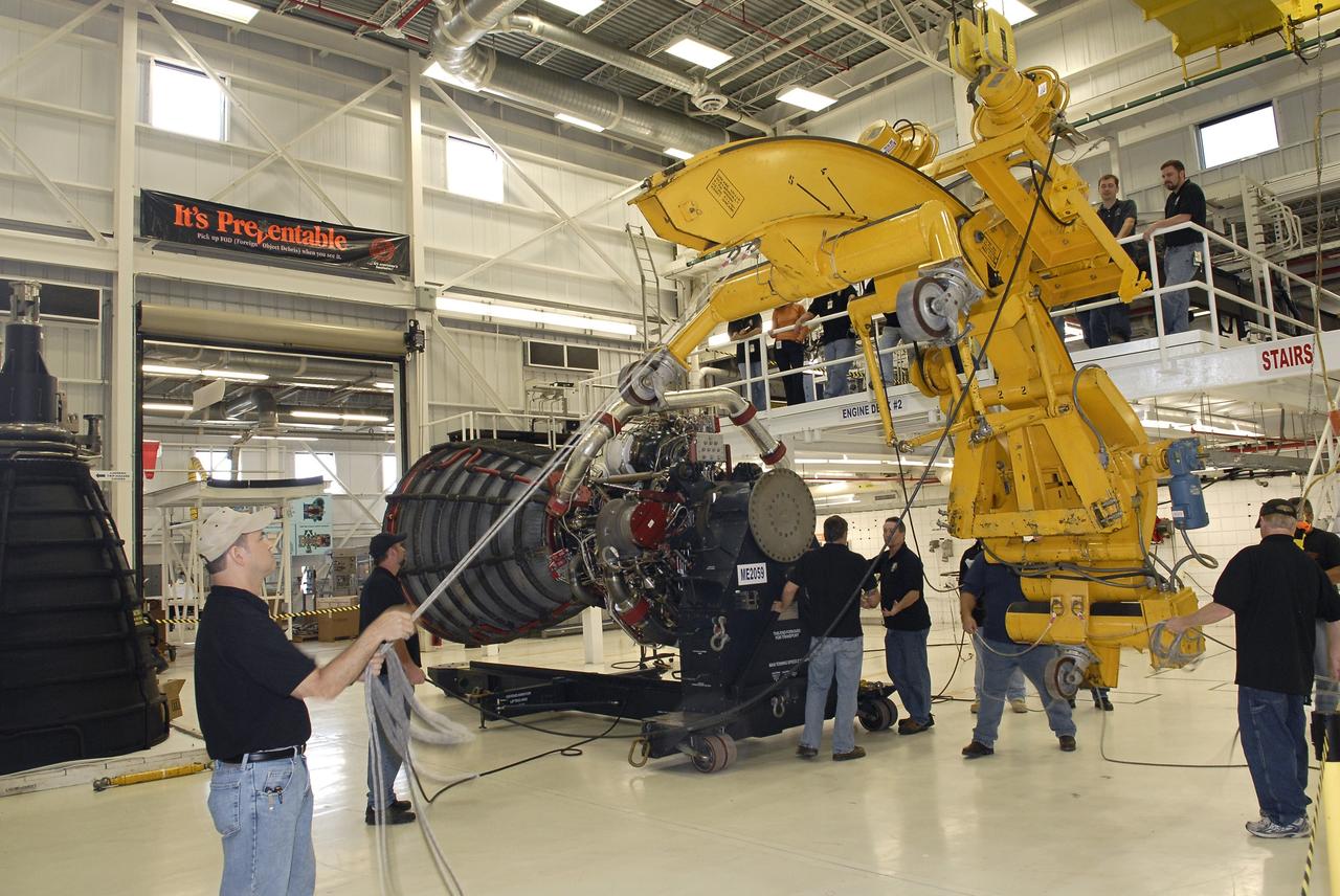 CAPE CANAVERAL, Fla. – A crane moves the engine-handling device away from the Pratt and Whitney Rocketdyne space shuttle main engine, or SSME, that it rotated into a horizontal position inside the SSME Processing Facility, the engine shop at NASA’s Kennedy Space Center in Florida.  The engine is secured on a portable workstand before being transferred into a transportation canister.    The engine is one of the last SSMEs remaining at Kennedy and is being prepared for shipment to NASA's Stennis Space Center in Mississippi. The first two groups of engines were shipped from Kennedy to Stennis in November 2011 and January 2012 the remaining engines are scheduled to depart on April 9.  Altogether, 15 shuttle-era engines will be stored at Stennis for reuse on NASA’s Space Launch System heavy-lift rocket, under development. Photo credit: NASA/Tim Jacobs