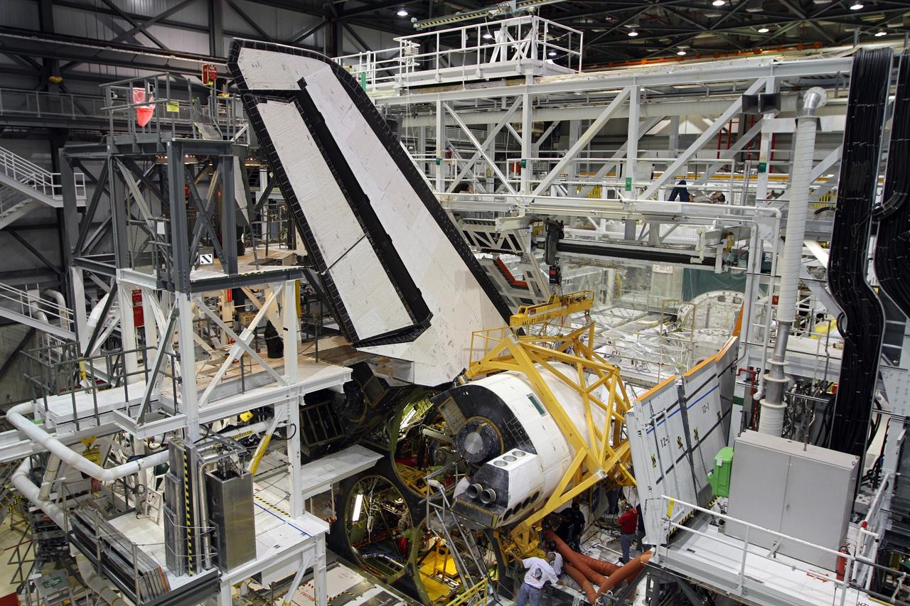 CAPE CANAVERAL, Fla. – In Orbiter Processing Facility-2 at NASA’s Kennedy Space Center in Florida, United Space Alliance technicians assist with the installation of the right orbital maneuvering system OMS pod on space shuttle Endeavour. The OMS pod underwent complete deservicing and cleaning at White Sands Space Harbor in New Mexico, part of the transition and retirement processing of each shuttle. Endeavour is being prepared for public display at the California Science Center in Los Angeles. Over the course of its 19-year career, Endeavour spent 299 days in space during 25 missions. For more information, visit http://www.nasa.gov/shuttle. Photo credit: NASA/Kim Shiflett
