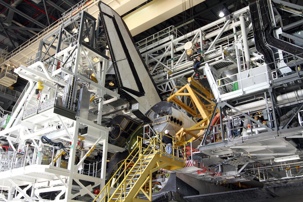 CAPE CANAVERAL, Fla. – In Orbiter Processing Facility-2 at NASA’s Kennedy Space Center in Florida, United Space Alliance technicians monitor the progress as the large crane that was used to lower the right orbital maneuvering system OMS pod onto space shuttle Endeavour is moved away. The OMS pod underwent complete deservicing and cleaning at White Sands Space Harbor in New Mexico, part of the transition and retirement processing of each shuttle. Endeavour is being prepared for public display at the California Science Center in Los Angeles. Over the course of its 19-year career, Endeavour spent 299 days in space during 25 missions. For more information, visit http://www.nasa.gov/shuttle. Photo credit: NASA/Kim Shiflett