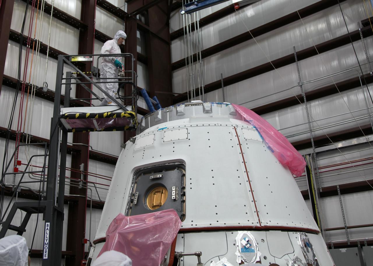 CAPE CANAVERAL, Fla. -- NASA astronaut Megan McArthur takes part in a crew equipment interface test CEIT in order to become familiar with the Space Exploration Technologies Corp. SpaceX Dragon capsule prior to its scheduled April 30 liftoff. The interface test inside a processing hangar at Cape Canaveral Air Force Station's Space Launch Complex-40 was part of prelaunch preparations for the company's next demonstration test flight for NASA's Commercial Orbital Transportation Services COTS program. Under COTS, NASA has partnered with two private companies to launch cargo safely to the International Space Station.    CEIT is an activity that dates back to NASA's Space Shuttle Program, providing astronauts on Earth an opportunity to work with the actual hardware they would use in space. This exercise gave astronauts and engineers the opportunity to assess the compatibility of the equipment and systems aboard Dragon with the procedures to be used by the flight crew and flight controllers once the capsule is berthed at the space station. For more information, visit www.nasa.gov/exploration/commercial/cargo/spacex_index.html. Image courtesy: SpaceX/Paul Bonness