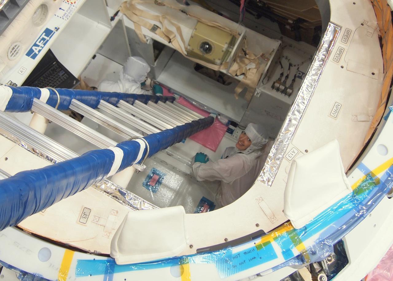 CAPE CANAVERAL, Fla. -- NASA astronaut Megan McArthur, right, takes part in a crew equipment interface test CEIT in order to become familiar with the Space Exploration Technologies Corp. SpaceX Dragon capsule prior to its scheduled April 30 liftoff. The interface test inside a processing hangar at Cape Canaveral Air Force Station's Space Launch Complex-40 was part of prelaunch preparations for the company's next demonstration test flight for NASA's Commercial Orbital Transportation Services COTS program. Under COTS, NASA has partnered with two private companies to launch cargo safely to the International Space Station. Jason Tenenbaum, with SpaceX Mission Operations, left, also takes part in the test.      CEIT is an activity that dates back to NASA's Space Shuttle Program, providing astronauts on Earth an opportunity to work with the actual hardware they would use in space. This exercise gave astronauts and engineers the opportunity to assess the compatibility of the equipment and systems aboard Dragon with the procedures to be used by the flight crew and flight controllers once the capsule is berthed at the space station. For more information, visit www.nasa.gov/exploration/commercial/cargo/spacex_index.html. Image courtesy: SpaceX/Paul Bonness