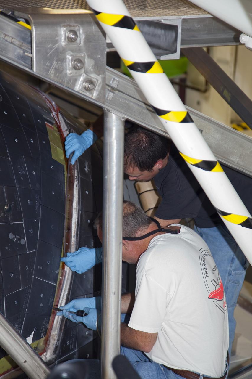 CAPE CANAVERAL, Fla. – In Orbiter Processing Facility-2 at NASA’s Kennedy Space Center in Florida, United Space Alliance technicians begin to bond and seal the tiles around the access panels to space shuttle Endeavour’s forward reaction control system, or FRCS. The FRCS helped a shuttle maneuver while in orbit. Endeavour’s FRCS was removed and sent to White Sands Test Facility in New Mexico to be cleaned of its toxic propellants and was reinstalled on the shuttle in February. Endeavour is being prepared for public display at the California Science Center in Los Angeles. Over the course of its 19-year career, Endeavour spent 299 days in space during 25 missions. For more information, visit http://www.nasa.gov/shuttle. Photo credit: NASA/Frankie Martin