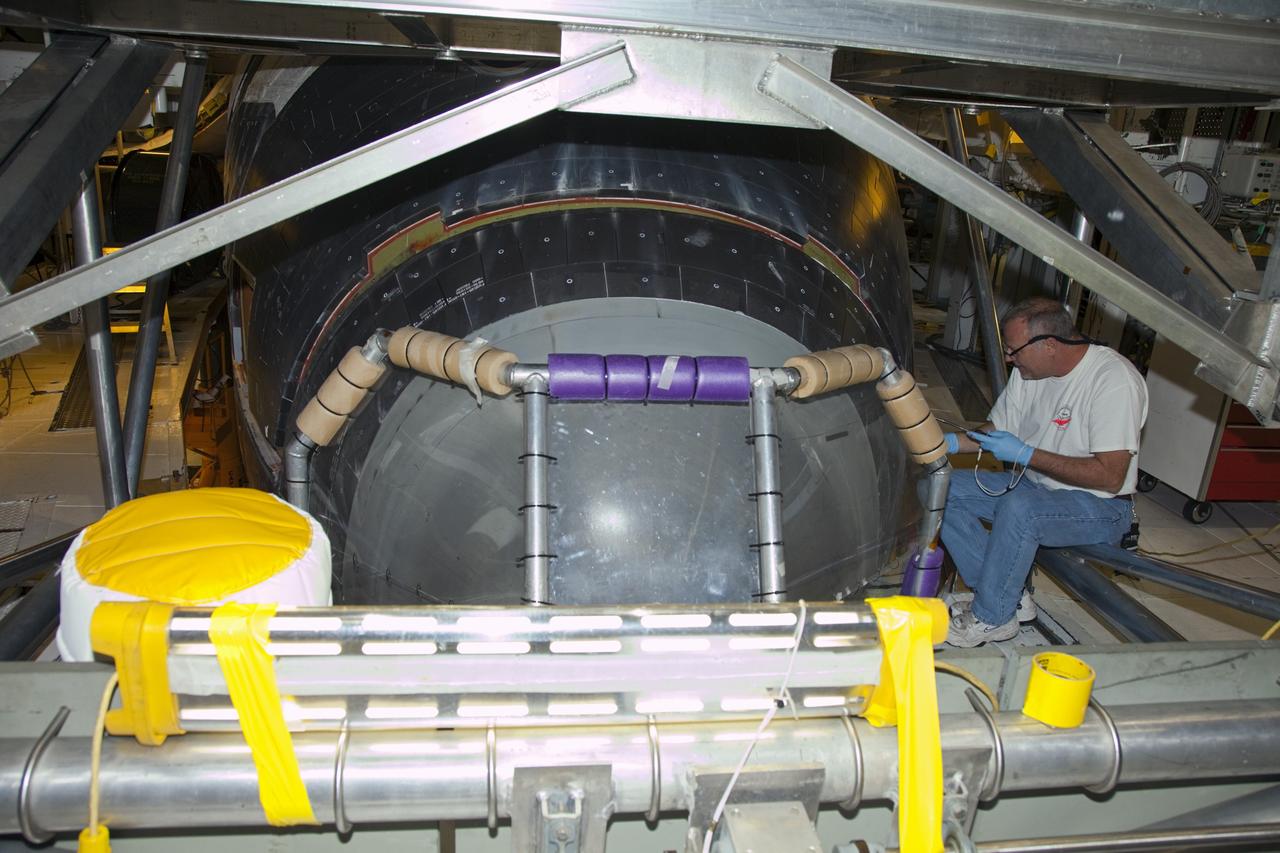 CAPE CANAVERAL, Fla. – In Orbiter Processing Facility-2 at NASA’s Kennedy Space Center in Florida, a United Space Alliance technician, with a tool tethered to his wrist, bonds and seals the tiles around the access panels to space shuttle Endeavour’s forward reaction control system, or FRCS. The FRCS helped a shuttle maneuver while in orbit. Endeavour’s FRCS was removed and sent to White Sands Test Facility in New Mexico to be cleaned of its toxic propellants and was reinstalled on the shuttle in February. Endeavour is being prepared for public display at the California Science Center in Los Angeles. Over the course of its 19-year career, Endeavour spent 299 days in space during 25 missions. For more information, visit http://www.nasa.gov/shuttle. Photo credit: NASA/Frankie Martin