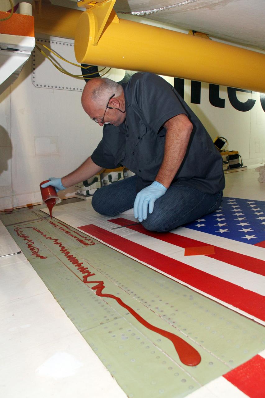 CAPE CANAVERAL, Fla. – Inside Orbiter Processing Facility-2 at NASA's Kennedy Space Center in Florida, Mike Williams, a thermal protection system technician with United Space Alliance, applies adhesive to the right wing of space shuttle Endeavour in preparation for tile bonding.    Ongoing transition and retirement activities are preparing the spacecraft for public display at the California Science Center in Los Angeles. Endeavour flew 25 missions during its 19-year career. Photo credit: NASA/Cory Huston