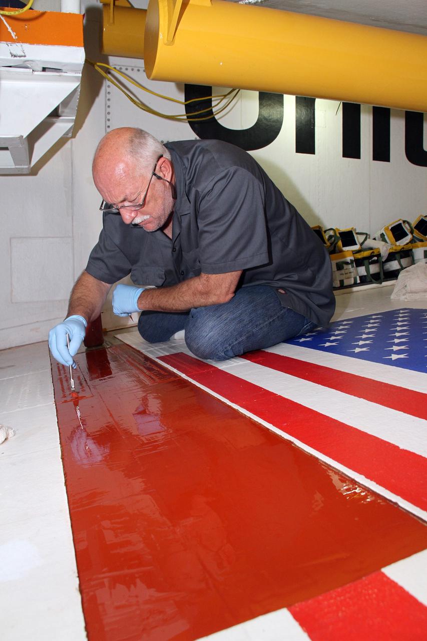 CAPE CANAVERAL, Fla. – Inside Orbiter Processing Facility-2 at NASA's Kennedy Space Center in Florida, Mike Williams, a thermal protection system technician with United Space Alliance, puts the finishing touches on a layer of adhesive applied to the right wing of space shuttle Endeavour. The work is being done in preparation for tile bonding.    Ongoing transition and retirement activities are preparing the spacecraft for public display at the California Science Center in Los Angeles. Endeavour flew 25 missions during its 19-year career. Photo credit: NASA/Cory Huston