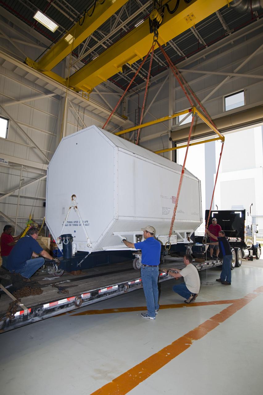 CAPE CANAVERAL, Fla. – In the Orbiter Processing Facility-3 engine shop at NASA's Kennedy Space Center in Florida, a transportation canister containing the last Pratt and Whitney Rocketdyne space shuttle main engine, or SSME, is lowered onto a flatbed truck for shipment to NASA's Stennis Space Center in Mississippi. The first two groups of engines were shipped from Kennedy to Stennis in November 2011 and January 2012 the remaining engines departed today. Altogether, 15 shuttle-era engines will be stored at Stennis for reuse on NASA’s Space Launch System heavy-lift rocket, under development. Photo credit: NASA/Dimitri Gerondidakis