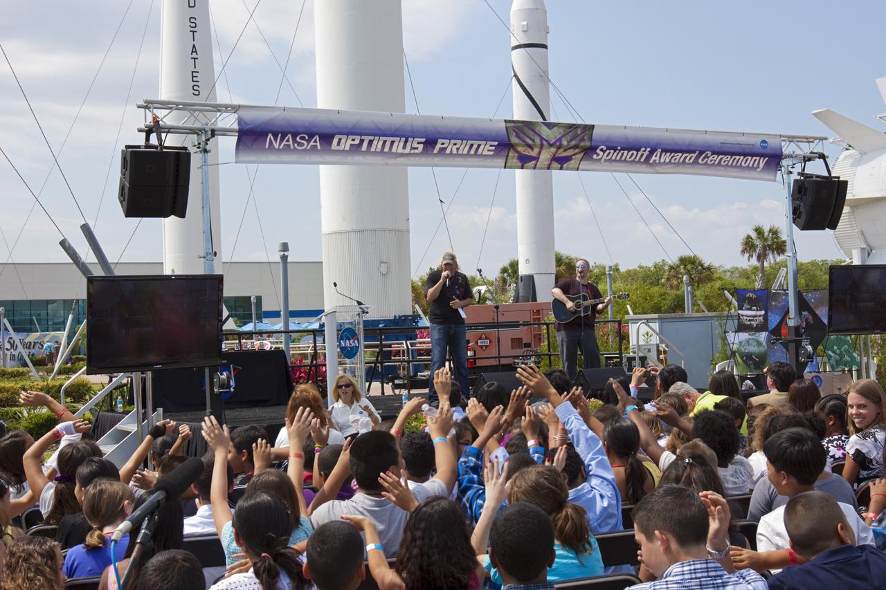 CAPE CANAVERAL, Fla. - Country music singer Ansel Brown, performs his song "When You Fly" for students and teachers involved with the NASA OPTIMUS PRIME Spinoff Video Contest in the Rocket Garden of the Kennedy Space Center Visitor Complex. The contest challenged students in grades three through 12 to study NASA spinoff technologies and produce short, creative videos promoting their favorites. The NASA Goddard Space Flight Center's Innovative Partnerships Office in Greenbelt, Md., designed the contest to help students see the benefits of NASA technology here on Earth. NASA collaborated with Hasbro in using the OPTIMUS PRIME character. Photo credit: NASA/Jim Grossmann