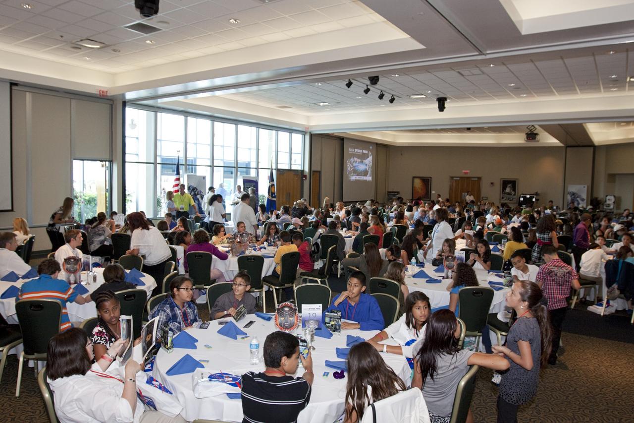 CAPE CANAVERAL, Fla. - Students and teachers of the NASA OPTIMUS PRIME Spinoff Video Contest await an award ceremony in the Debus Conference Center of the Kennedy Space Center Visitor Complex. The contest challenged students in grades three through 12 to study NASA spinoff technologies and produce short, creative videos promoting their favorites. The NASA Goddard Space Flight Center's Innovative Partnerships Office in Greenbelt, Md., designed the contest to help students see the benefits of NASA technology here on Earth. NASA collaborated with Hasbro in using the OPTIMUS PRIME character. Photo credit: NASA/Jim Grossmann