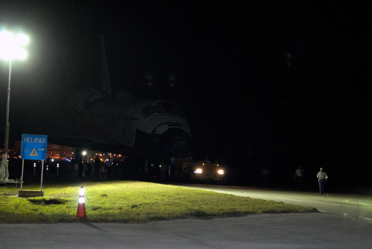 CAPE CANAVERAL, Fla. – A team of aerospace workers accompanies space shuttle Discovery along the towway to the Shuttle Landing Facility, or SLF, at NASA’s Kennedy Space Center in Florida.     At the SLF, Discovery will be hoisted onto a Shuttle Carrier Aircraft, or SCA, with the aid of a mate-demate device.  The SCA, a modified Boeing 747 jet airliner, is scheduled to ferry Discovery to the Washington Dulles International Airport in Virginia on April 17, after which the shuttle will be placed on permanent public display in the Smithsonian's National Air and Space Museum Steven F. Udvar-Hazy Center.  For more information on shuttle transition and retirement activities, visit http://www.nasa.gov/transition. Photo credit: NASA/Tim Jacobs
