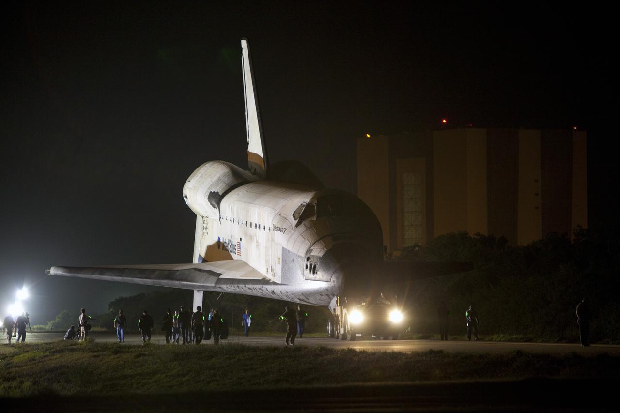 CAPE CANAVERAL, Fla. – A team of aerospace workers accompanies space shuttle Discovery as it is towed to the Shuttle Landing Facility, or SLF, in darkness at NASA’s Kennedy Space Center in Florida.  Its move from the Vehicle Assembly Building, in the background, got under way at 5 a.m. EDT.    At the SLF, Discovery will be hoisted onto a Shuttle Carrier Aircraft, or SCA, with the aid of a mate-demate device.  The SCA, a modified Boeing 747 jet airliner, is scheduled to ferry Discovery to the Washington Dulles International Airport in Virginia on April 17, after which the shuttle will be placed on permanent public display in the Smithsonian's National Air and Space Museum Steven F. Udvar-Hazy Center.  For more information on shuttle transition and retirement activities, visit http://www.nasa.gov/transition. Photo credit: NASA/Dimitri Gerondidakis