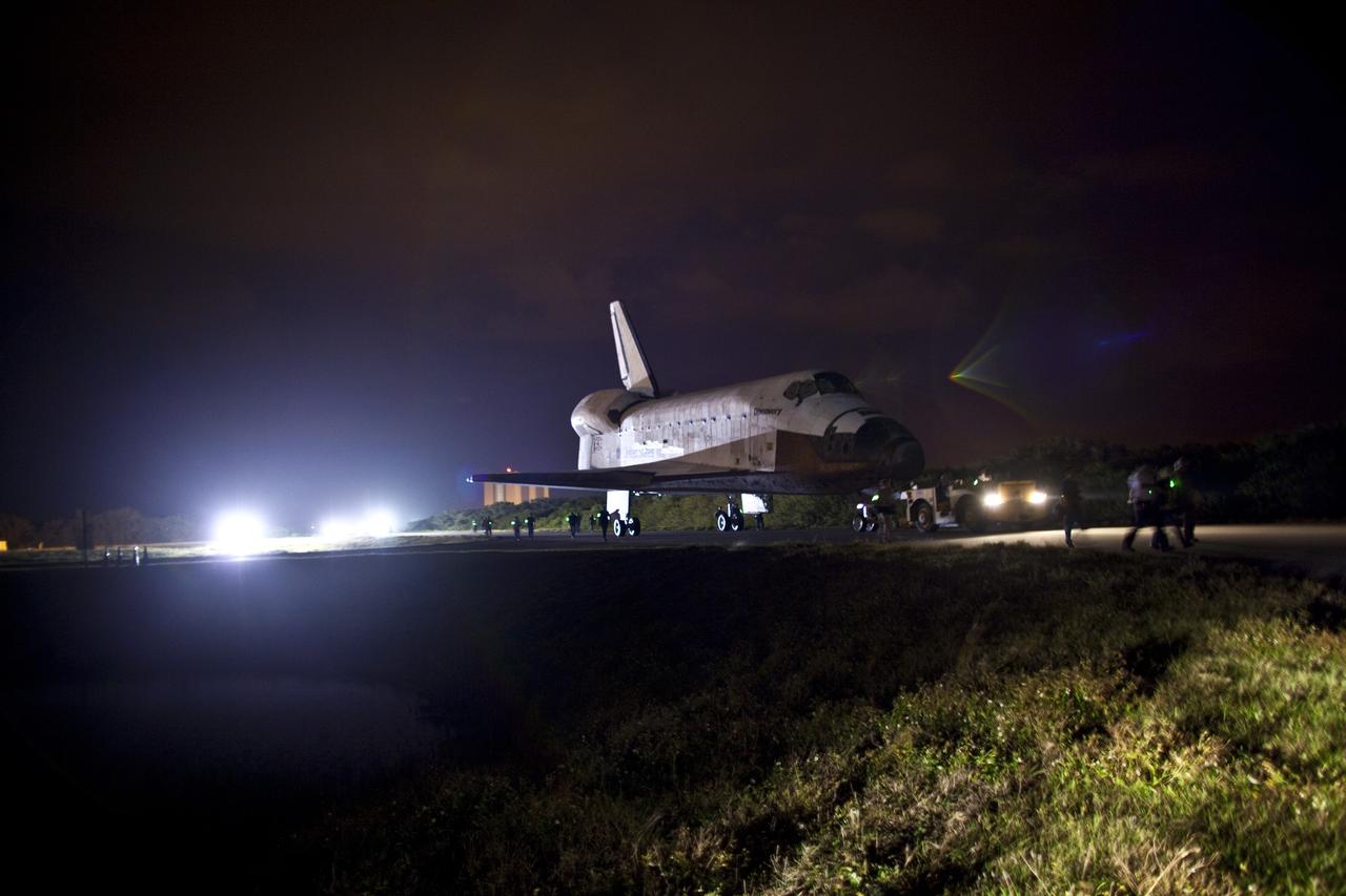 CAPE CANAVERAL, Fla. – Space shuttle Discovery is towed along the access road to the Shuttle Landing Facility, or SLF, before dawn at NASA’s Kennedy Space Center in Florida. Its move from the Vehicle Assembly Building got under way at 5 a.m. EDT. At the SLF, Discovery will be hoisted onto a Shuttle Carrier Aircraft, or SCA, with the aid of a mate-demate device. The SCA, a modified Boeing 747 jet airliner, is scheduled to ferry Discovery to the Washington Dulles International Airport in Virginia on April 17, after which the shuttle will be placed on permanent public display in the Smithsonian's National Air and Space Museum Steven F. Udvar-Hazy Center. For more information on shuttle transition and retirement activities, visit http://www.nasa.gov/transition. Photo credit: NASA/Dimitri Gerondidakis