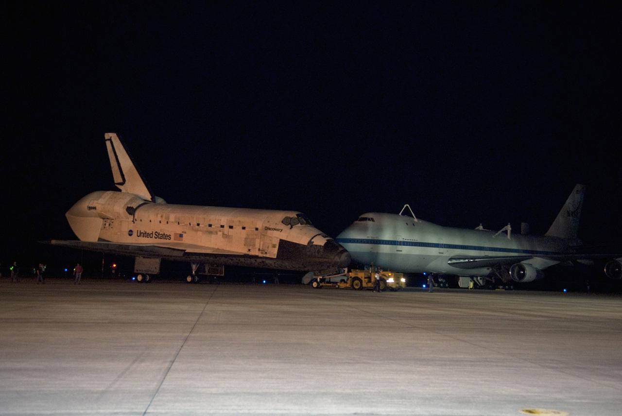CAPE CANAVERAL, Fla. – Space shuttle Discovery rolls past a Shuttle Carrier Aircraft, or SCA, at the Shuttle Landing Facility at NASA’s Kennedy Space Center in Florida. This SCA, designated NASA 905, is a Boeing 747 jet originally manufactured for commercial use, which was modified by NASA to transport the shuttles between destinations on Earth. NASA 905 is assigned to the remaining ferry missions, delivering the shuttles to their permanent public display sites. Discovery’s new home will be the Smithsonian's National Air and Space Museum Steven F. Udvar-Hazy Center in Chantilly, Va. For more information on the SCA, visit http://www.nasa.gov/centers/dryden/news/FactSheets/FS-013-DFRC.html. For more information on shuttle transition and retirement activities, visit http://www.nasa.gov/transition. Photo credit: NASA/Tim Jacobs