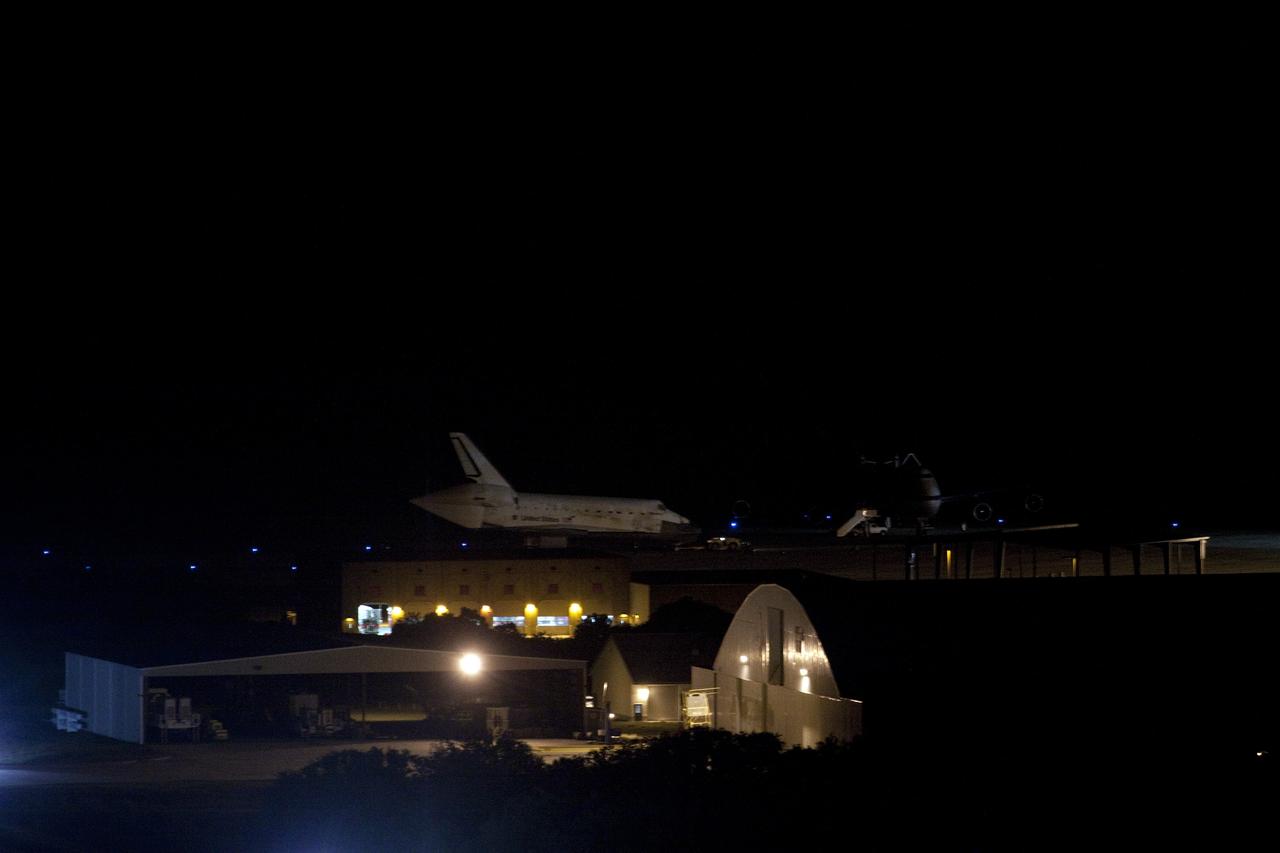 CAPE CANAVERAL, Fla. – At the Shuttle Landing Facility, or SLF, at NASA’s Kennedy Space Center in Florida, space shuttle Discovery rolls past the Shuttle Carrier Aircraft with which it will be mated.     Discovery will be hoisted onto the SCA with the aid of a mate-demate device.  The SCA, a modified Boeing 747 jet airliner, is scheduled to ferry Discovery to the Washington Dulles International Airport in Virginia on April 17, after which the shuttle will be placed on permanent public display in the Smithsonian's National Air and Space Museum Steven F. Udvar-Hazy Center.  For more information on shuttle transition and retirement activities, visit http://www.nasa.gov/transition. Photo credit: NASA/Jim Grossmann