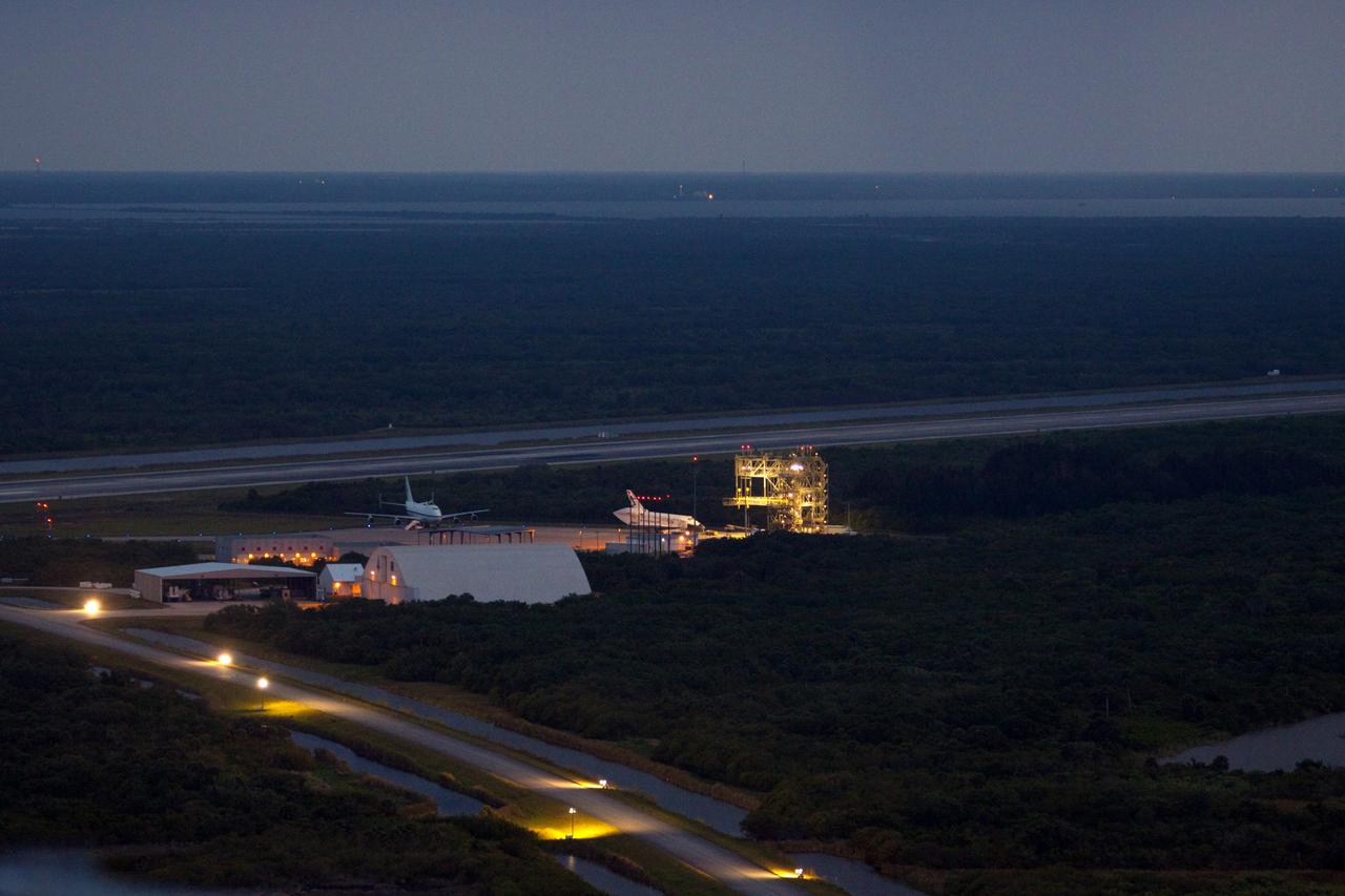 CAPE CANAVERAL, Fla. – At the Shuttle Landing Facility at NASA’s Kennedy Space Center in Florida, space shuttle Discovery rolls past a Shuttle Carrier Aircraft, or SCA, toward the mate-demate device, or MDD. A tail cone has been installed over its three replica shuttle main engines to reduce aerodynamic drag and turbulence during its upcoming ferry flight.    The MDD is a large gantry-like steel structure used to hoist a shuttle off the ground and position it onto the back of an SCA. The SCA is a Boeing 747 jet, originally manufactured for commercial use, which was modified by NASA to transport the shuttles between destinations on Earth.  The SCA designated NASA 905 is assigned to the remaining ferry missions, delivering the shuttles to their permanent public display sites.  NASA 905 is scheduled to ferry Discovery to the Washington Dulles International Airport in Virginia on April 17, after which the shuttle will be placed on display in the Smithsonian's National Air and Space Museum Steven F. Udvar-Hazy Center. For more information on the SCA, visit http://www.nasa.gov/centers/dryden/news/FactSheets/FS-013-DFRC.html. For more information on shuttle transition and retirement activities, visit http://www.nasa.gov/transition. Photo credit: NASA/Jim Grossmann