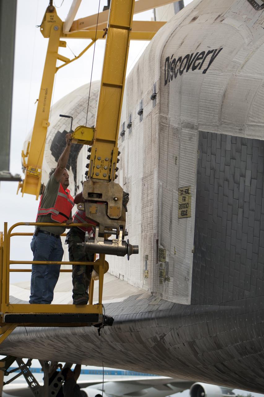 CAPE CANAVERAL, Fla. – At the Shuttle Landing Facility at NASA’s Kennedy Space Center in Florida, workers secure a sling to space shuttle Discovery to enable the mate-demate device to lift it onto a Shuttle Carrier Aircraft. The device, known as the MDD, is a large gantry-like steel structure used to hoist a shuttle off the ground and position it onto the back of the aircraft, or SCA. The SCA is a Boeing 747 jet, originally manufactured for commercial use, which was modified by NASA to transport the shuttles between destinations on Earth. The SCA designated NASA 905 is assigned to the remaining ferry missions, delivering the shuttles to their permanent public display sites. NASA 905 is scheduled to ferry Discovery to the Washington Dulles International Airport in Virginia on April 17, after which the shuttle will be placed on display in the Smithsonian's National Air and Space Museum Steven F. Udvar-Hazy Center. For more information on the SCA, visit http://www.nasa.gov/centers/dryden/news/FactSheets/FS-013-DFRC.html. For more information on shuttle transition and retirement activities, visit http://www.nasa.gov/transition. Photo credit: NASA/Dimitri Gerondidakis