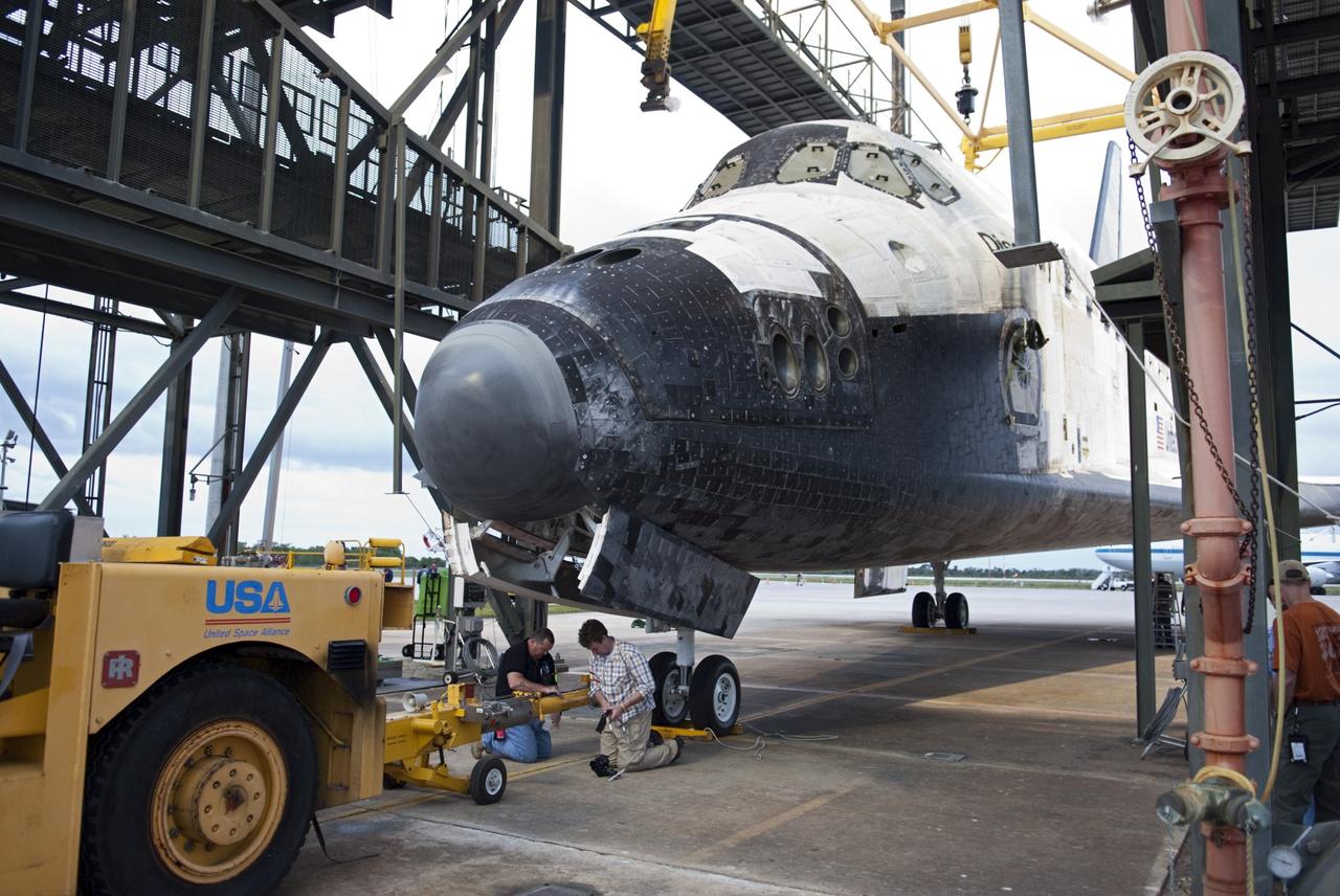 CAPE CANAVERAL, Fla. – At the Shuttle Landing Facility at NASA’s Kennedy Space Center in Florida, workers disconnect the tow vehicle from space shuttle Discovery before it is lifted onto the top of a Shuttle Carrier Aircraft with the aid of the mate-demate device. The device, known as the MDD, is a large gantry-like steel structure used to hoist a shuttle off the ground and position it onto the back of the aircraft, or SCA. The SCA is a Boeing 747 jet, originally manufactured for commercial use, which was modified by NASA to transport the shuttles between destinations on Earth. The SCA designated NASA 905 is assigned to the remaining ferry missions, delivering the shuttles to their permanent public display sites. NASA 905 is scheduled to ferry Discovery to the Washington Dulles International Airport in Virginia on April 17, after which the shuttle will be placed on display in the Smithsonian's National Air and Space Museum Steven F. Udvar-Hazy Center. For more information on the SCA, visit http://www.nasa.gov/centers/dryden/news/FactSheets/FS-013-DFRC.html. For more information on shuttle transition and retirement activities, visit http://www.nasa.gov/transition. Photo credit: NASA/Dimitri Gerondidakis