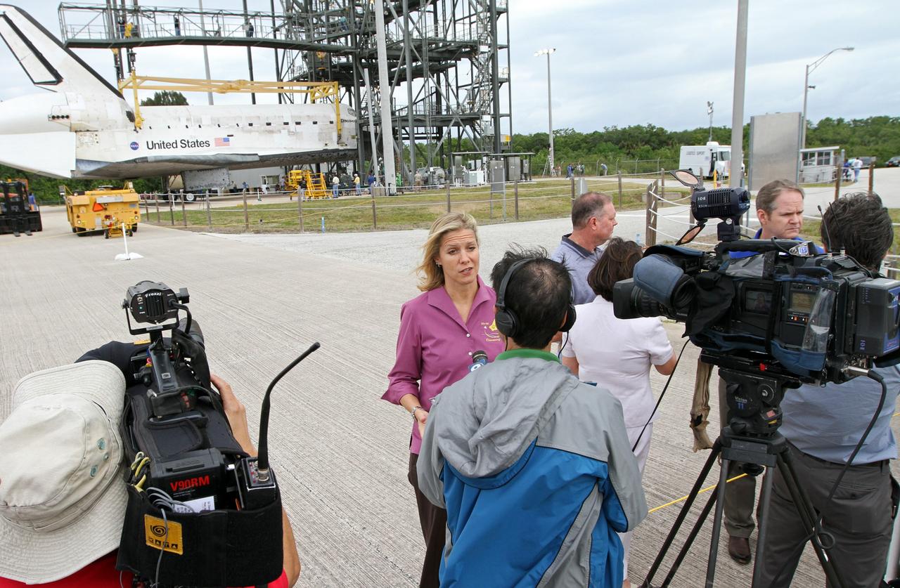 CAPE CANAVERAL, Fla. – At the Shuttle Landing Facility at NASA’s Kennedy Space Center in Florida, media representatives interview Stephanie Stilson, center, the NASA flow director for Orbiter Transition and Retirement at Kennedy following the arrival of space shuttle Discovery. Operations are under way at the mate-demate device, in the background, to lift Discovery on top of a Shuttle Carrier Aircraft. The device, known as the MDD, is a large gantry-like steel structure used to hoist a shuttle off the ground and position it onto the back of the aircraft, or SCA. The SCA is a Boeing 747 jet, originally manufactured for commercial use, which was modified by NASA to transport the shuttles between destinations on Earth. The SCA designated NASA 905 is assigned to the remaining ferry missions, delivering the shuttles to their permanent public display sites.  NASA 905 is scheduled to ferry Discovery to the Washington Dulles International Airport in Virginia on April 17, after which the shuttle will be placed on display in the Smithsonian's National Air and Space Museum Steven F. Udvar-Hazy Center. For more information on the SCA, visit http://www.nasa.gov/centers/dryden/news/FactSheets/FS-013-DFRC.html. For more information on shuttle transition and retirement activities, visit http://www.nasa.gov/transition. Photo credit: NASA/Kim Shiflett