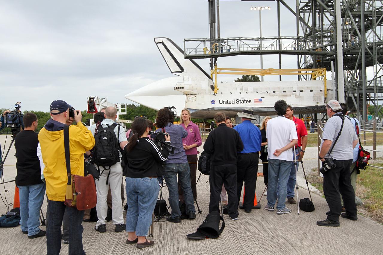 CAPE CANAVERAL, Fla. – At the Shuttle Landing Facility at NASA’s Kennedy Space Center in Florida, media representatives interview Stephanie Stilson, center, the NASA flow director for Orbiter Transition and Retirement at Kennedy following the arrival of space shuttle Discovery. Operations are under way at the mate-demate device, in the background, to lift Discovery on top of a Shuttle Carrier Aircraft. The device, known as the MDD, is a large gantry-like steel structure used to hoist a shuttle off the ground and position it onto the back of the aircraft, or SCA. The SCA is a Boeing 747 jet, originally manufactured for commercial use, which was modified by NASA to transport the shuttles between destinations on Earth. The SCA designated NASA 905 is assigned to the remaining ferry missions, delivering the shuttles to their permanent public display sites.  NASA 905 is scheduled to ferry Discovery to the Washington Dulles International Airport in Virginia on April 17, after which the shuttle will be placed on display in the Smithsonian's National Air and Space Museum Steven F. Udvar-Hazy Center. For more information on the SCA, visit http://www.nasa.gov/centers/dryden/news/FactSheets/FS-013-DFRC.html. For more information on shuttle transition and retirement activities, visit http://www.nasa.gov/transition. Photo credit: NASA/Kim Shiflett