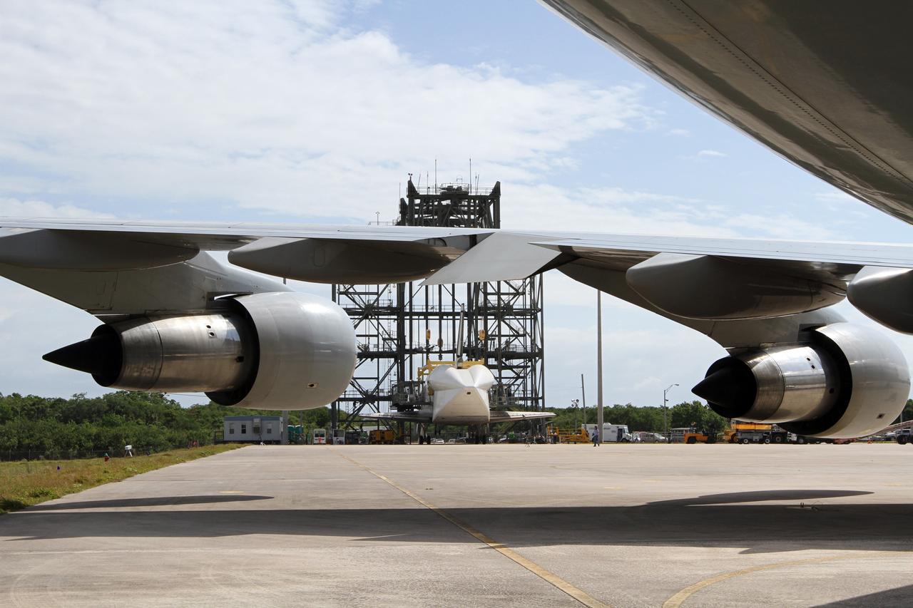 CAPE CANAVERAL, Fla. – At the Shuttle Landing Facility at NASA’s Kennedy Space Center in Florida, the camera view from under the wing of a Shuttle Carrier Aircraft finds space shuttle Discovery at the mate-demate device, in the distance. Operations are under way to lift Discovery on top of the aircraft. The device, known as the MDD, is a large gantry-like steel structure used to hoist a shuttle off the ground and position it onto the back of the aircraft, or SCA. The SCA is a Boeing 747 jet, originally manufactured for commercial use, which was modified by NASA to transport the shuttles between destinations on Earth. The SCA designated NASA 905 is assigned to the remaining ferry missions, delivering the shuttles to their permanent public display sites. NASA 905 is scheduled to ferry Discovery to the Washington Dulles International Airport in Virginia on April 17, after which the shuttle will be placed on display in the Smithsonian's National Air and Space Museum Steven F. Udvar-Hazy Center. For more information on the SCA, visit http://www.nasa.gov/centers/dryden/news/FactSheets/FS-013-DFRC.html. For more information on shuttle transition and retirement activities, visit http://www.nasa.gov/transition. Photo credit: NASA/Kim Shiflett