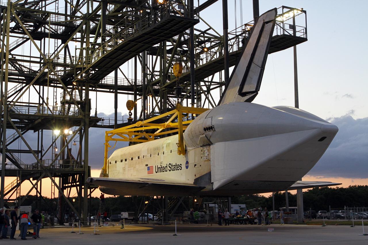 CAPE CANAVERAL, Fla. – As the sun comes up over the Shuttle Landing Facility at NASA’s Kennedy Space Center in Florida, space shuttle Discovery is suspended above the ground at the mate-demate device during operations to place it on top of a Shuttle Carrier Aircraft. A tail cone has been installed over Discovery’s three replica shuttle main engines to reduce aerodynamic drag and turbulence during the ferry flight.     The device, known as the MDD, is a large gantry-like steel structure used to hoist a shuttle off the ground and position it onto the back of the aircraft, or SCA. The SCA is a Boeing 747 jet, originally manufactured for commercial use, which was modified by NASA to transport the shuttles between destinations on Earth. The SCA designated NASA 905 is assigned to the remaining ferry missions, delivering the shuttles to their permanent public display sites.  NASA 905 is scheduled to ferry Discovery to the Washington Dulles International Airport in Virginia on April 17, after which the shuttle will be placed on display in the Smithsonian's National Air and Space Museum Steven F. Udvar-Hazy Center. For more information on the SCA, visit http://www.nasa.gov/centers/dryden/news/FactSheets/FS-013-DFRC.html. For more information on shuttle transition and retirement activities, visit http://www.nasa.gov/transition. Photo credit: NASA/Kim Shiflett