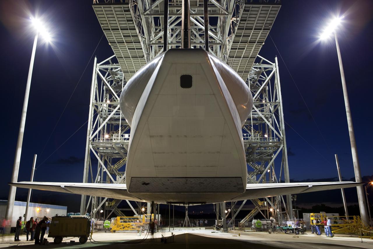CAPE CANAVERAL, Fla. – Before daybreak at the Shuttle Landing Facility at NASA’s Kennedy Space Center in Florida, space shuttle Discovery hovers above the ground at the mate-demate device. Operations are under way to position Discovery on top of a Shuttle Carrier Aircraft in preparation for its departure from Kennedy on Tuesday. A tail cone has been installed over Discovery’s three replica shuttle main engines to reduce aerodynamic drag and turbulence during the ferry flight.    The device, known as the MDD, is a large gantry-like steel structure used to hoist a shuttle off the ground and position it onto the back of the aircraft, or SCA. The SCA is a Boeing 747 jet, originally manufactured for commercial use, which was modified by NASA to transport the shuttles between destinations on Earth. The SCA designated NASA 905 is assigned to the remaining ferry missions, delivering the shuttles to their permanent public display sites.  NASA 905 is scheduled to ferry Discovery to the Washington Dulles International Airport in Virginia on April 17, after which the shuttle will be placed on display in the Smithsonian's National Air and Space Museum Steven F. Udvar-Hazy Center. For more information on the SCA, visit http://www.nasa.gov/centers/dryden/news/FactSheets/FS-013-DFRC.html. For more information on shuttle transition and retirement activities, visit http://www.nasa.gov/transition. Photo credit: NASA/Dimitri Gerondidakis