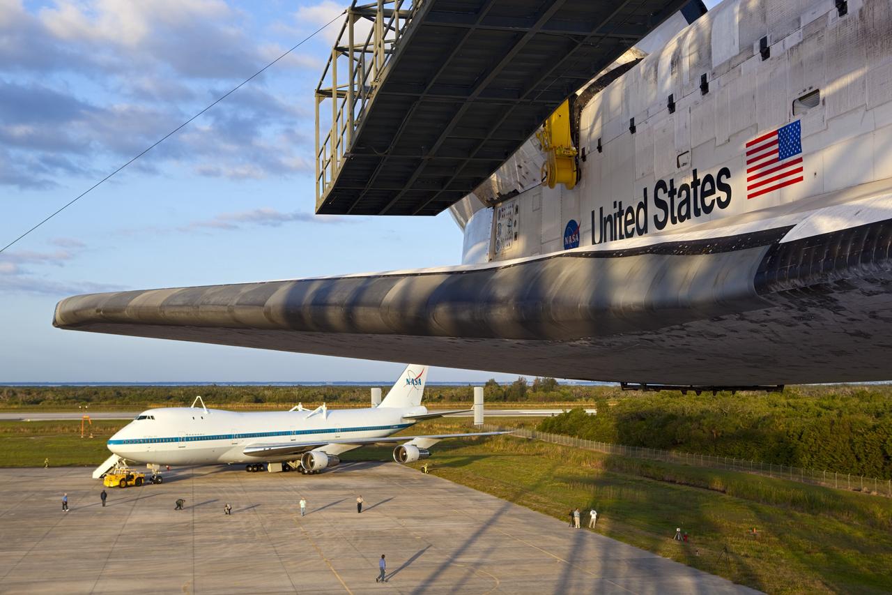 CAPE CANAVERAL, Fla. – At the Shuttle Landing Facility at NASA’s Kennedy Space Center in Florida, preparations are under way to tow a Shuttle Carrier Aircraft to the mate-demate device for mating with space shuttle Discovery, in the foreground. This SCA, designated NASA 905, is a Boeing 747 jet originally manufactured for commercial use, which was modified by NASA to transport the shuttles between destinations on Earth. NASA 905 is assigned to the remaining ferry missions, delivering the shuttles to their permanent public display sites. Discovery’s new home will be the Smithsonian's National Air and Space Museum Steven F. Udvar-Hazy Center in Chantilly, Va. For more information on the SCA, visit http://www.nasa.gov/centers/dryden/news/FactSheets/FS-013-DFRC.html. For more information on shuttle transition and retirement activities, visit http://www.nasa.gov/transition. Photo credit: NASA/Dimitri Gerondidakis