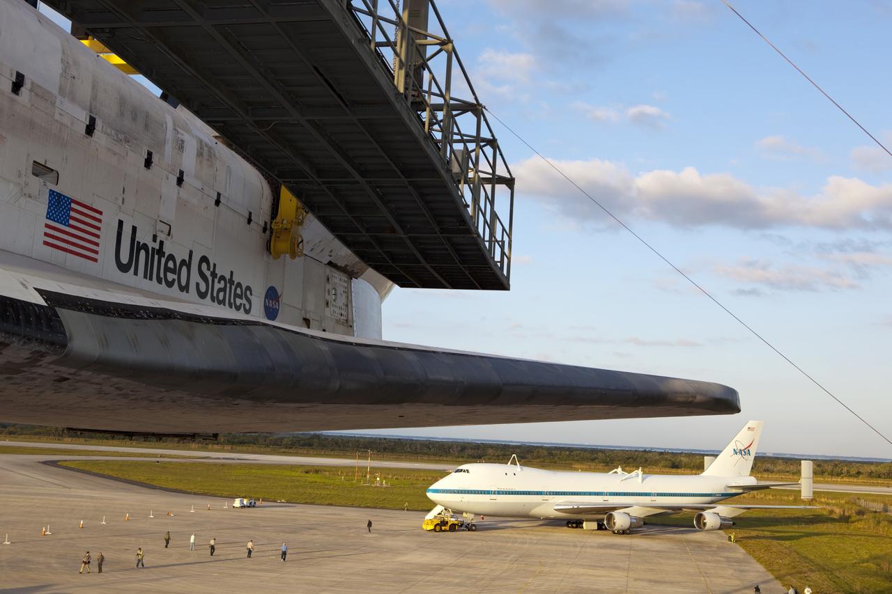 CAPE CANAVERAL, Fla. – At the Shuttle Landing Facility at NASA’s Kennedy Space Center in Florida, preparations are under way to tow a Shuttle Carrier Aircraft to the mate-demate device for mating with space shuttle Discovery, in the foreground. This SCA, designated NASA 905, is a Boeing 747 jet originally manufactured for commercial use, which was modified by NASA to transport the shuttles between destinations on Earth. NASA 905 is assigned to the remaining ferry missions, delivering the shuttles to their permanent public display sites. Discovery’s new home will be the Smithsonian's National Air and Space Museum Steven F. Udvar-Hazy Center in Chantilly, Va. For more information on the SCA, visit http://www.nasa.gov/centers/dryden/news/FactSheets/FS-013-DFRC.html. For more information on shuttle transition and retirement activities, visit http://www.nasa.gov/transition. Photo credit: NASA/Dimitri Gerondidakis
