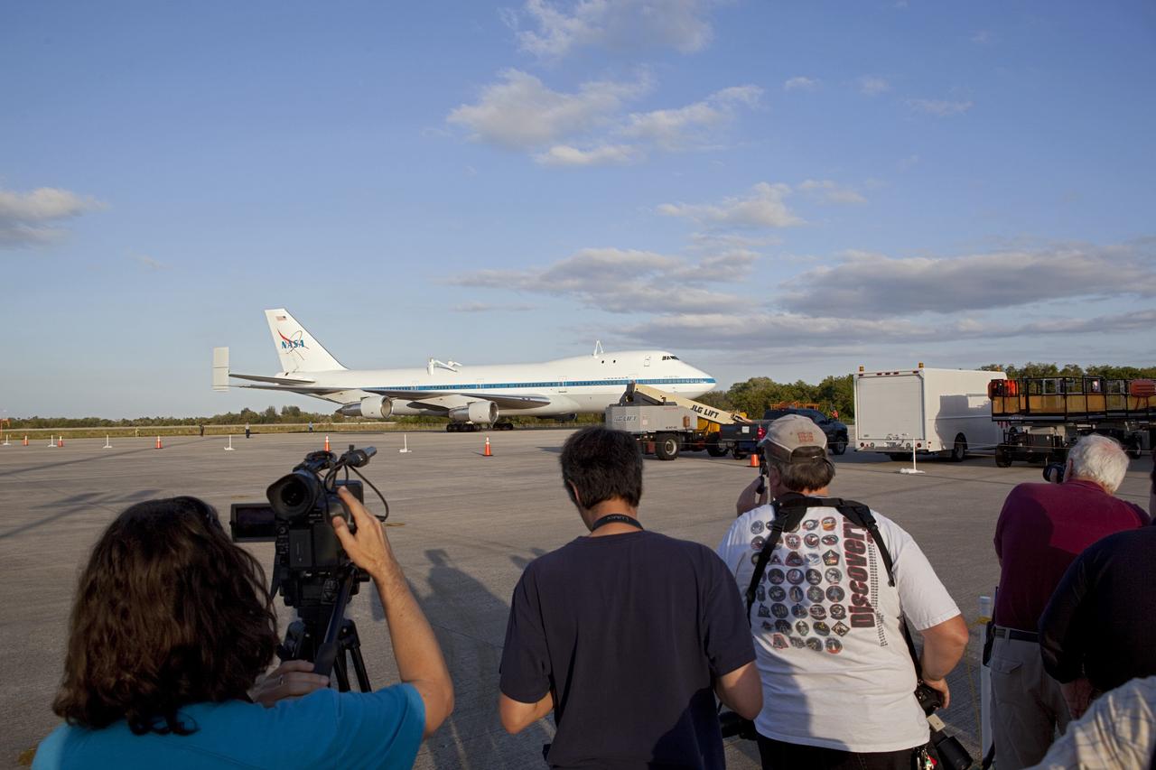 CAPE CANAVERAL, Fla. – At the Shuttle Landing Facility at NASA’s Kennedy Space Center in Florida, media representatives are on hand as the Shuttle Carrier Aircraft is towed to the mate-demate device for mating with space shuttle Discovery. The aircraft, or SCA, is a Boeing 747 jet, originally manufactured for commercial use, which was modified by NASA to transport the shuttles between destinations on Earth. The SCA designated NASA 905 is assigned to the remaining ferry missions, delivering the shuttles to their permanent public display sites.  NASA 905 is scheduled to ferry Discovery to the Washington Dulles International Airport in Virginia on April 17, after which the shuttle will be placed on display in the Smithsonian's National Air and Space Museum Steven F. Udvar-Hazy Center. For more information on the SCA, visit http://www.nasa.gov/centers/dryden/news/FactSheets/FS-013-DFRC.html. For more information on shuttle transition and retirement activities, visit http://www.nasa.gov/transition.  Photo credit: NASA/Dimitri Gerondidakis