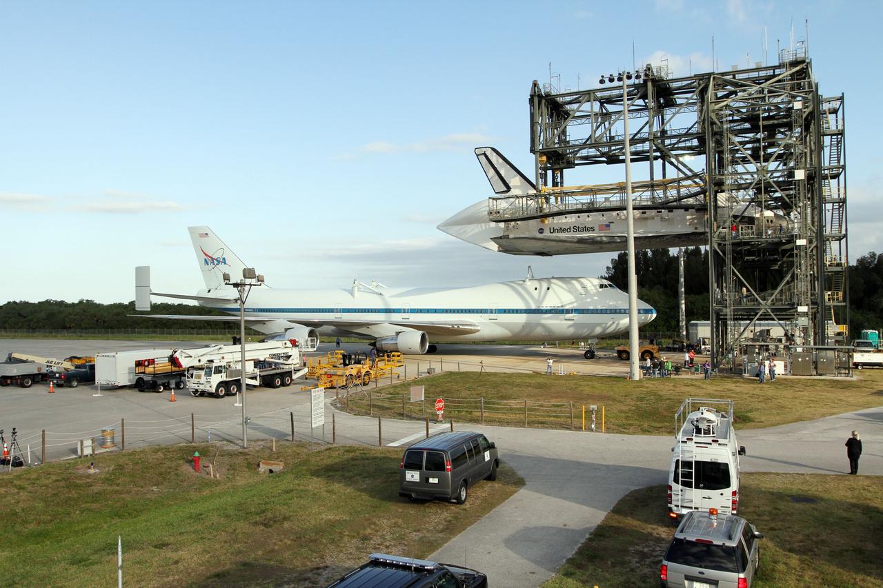 CAPE CANAVERAL, Fla. – At the Shuttle Landing Facility at NASA’s Kennedy Space Center in Florida, the Shuttle Carrier Aircraft moves into position under space shuttle Discovery suspended 60 feet off the ground in the mate-demate device.     The device, known as the MDD, is a large gantry-like steel structure used to hoist a shuttle off the ground and position it onto the back of the aircraft, or SCA. The SCA is a Boeing 747 jet, originally manufactured for commercial use, which was modified by NASA to transport the shuttles between destinations on Earth. The SCA designated NASA 905 is assigned to the remaining ferry missions, delivering the shuttles to their permanent public display sites.  NASA 905 is scheduled to ferry Discovery to the Washington Dulles International Airport in Virginia on April 17, after which the shuttle will be placed on display in the Smithsonian's National Air and Space Museum Steven F. Udvar-Hazy Center. For more information on the SCA, visit http://www.nasa.gov/centers/dryden/news/FactSheets/FS-013-DFRC.html. For more information on shuttle transition and retirement activities, visit http://www.nasa.gov/transition. Photo credit: NASA/Kim Shiflett