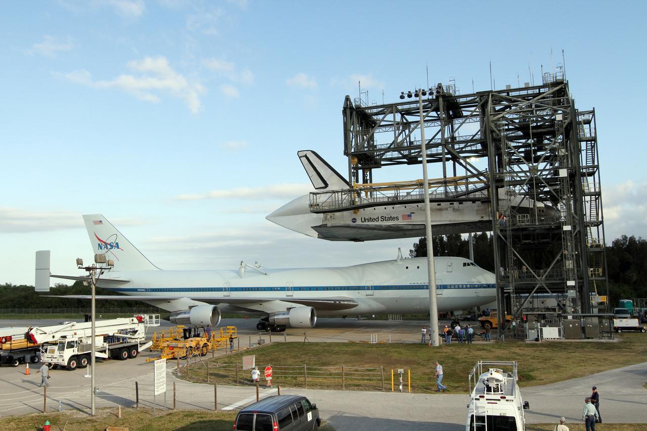 CAPE CANAVERAL, Fla. – At the Shuttle Landing Facility at NASA’s Kennedy Space Center in Florida, the Shuttle Carrier Aircraft moves into position under space shuttle Discovery suspended 60 feet off the ground in the mate-demate device.     The device, known as the MDD, is a large gantry-like steel structure used to hoist a shuttle off the ground and position it onto the back of the aircraft, or SCA. The SCA is a Boeing 747 jet, originally manufactured for commercial use, which was modified by NASA to transport the shuttles between destinations on Earth. The SCA designated NASA 905 is assigned to the remaining ferry missions, delivering the shuttles to their permanent public display sites.  NASA 905 is scheduled to ferry Discovery to the Washington Dulles International Airport in Virginia on April 17, after which the shuttle will be placed on display in the Smithsonian's National Air and Space Museum Steven F. Udvar-Hazy Center. For more information on the SCA, visit http://www.nasa.gov/centers/dryden/news/FactSheets/FS-013-DFRC.html. For more information on shuttle transition and retirement activities, visit http://www.nasa.gov/transition. Photo credit: NASA/Kim Shiflett