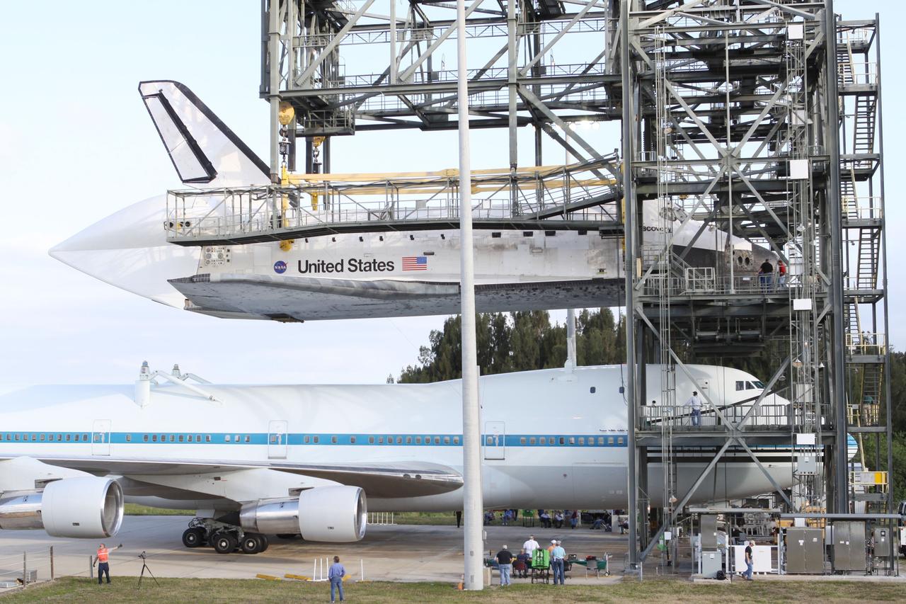 CAPE CANAVERAL, Fla. – At the Shuttle Landing Facility at NASA’s Kennedy Space Center in Florida, the Shuttle Carrier Aircraft moves into position under space shuttle Discovery suspended 60 feet off the ground in the mate-demate device.     The device, known as the MDD, is a large gantry-like steel structure used to hoist a shuttle off the ground and position it onto the back of the aircraft, or SCA. The SCA is a Boeing 747 jet, originally manufactured for commercial use, which was modified by NASA to transport the shuttles between destinations on Earth. The SCA designated NASA 905 is assigned to the remaining ferry missions, delivering the shuttles to their permanent public display sites.  NASA 905 is scheduled to ferry Discovery to the Washington Dulles International Airport in Virginia on April 17, after which the shuttle will be placed on display in the Smithsonian's National Air and Space Museum Steven F. Udvar-Hazy Center. For more information on the SCA, visit http://www.nasa.gov/centers/dryden/news/FactSheets/FS-013-DFRC.html. For more information on shuttle transition and retirement activities, visit http://www.nasa.gov/transition. Photo credit: NASA/Kim Shiflett