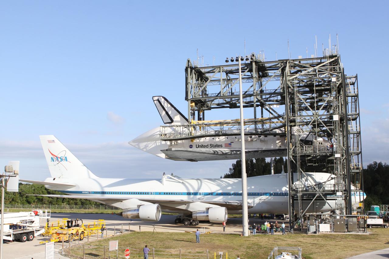 CAPE CANAVERAL, Fla. – At the Shuttle Landing Facility at NASA’s Kennedy Space Center in Florida, the Shuttle Carrier Aircraft moves into position under space shuttle Discovery suspended 60 feet off the ground in the mate-demate device.     The device, known as the MDD, is a large gantry-like steel structure used to hoist a shuttle off the ground and position it onto the back of the aircraft, or SCA. The SCA is a Boeing 747 jet, originally manufactured for commercial use, which was modified by NASA to transport the shuttles between destinations on Earth. The SCA designated NASA 905 is assigned to the remaining ferry missions, delivering the shuttles to their permanent public display sites.  NASA 905 is scheduled to ferry Discovery to the Washington Dulles International Airport in Virginia on April 17, after which the shuttle will be placed on display in the Smithsonian's National Air and Space Museum Steven F. Udvar-Hazy Center. For more information on the SCA, visit http://www.nasa.gov/centers/dryden/news/FactSheets/FS-013-DFRC.html. For more information on shuttle transition and retirement activities, visit http://www.nasa.gov/transition. Photo credit: NASA/Kim Shiflett