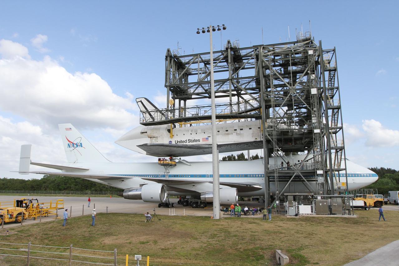 CAPE CANAVERAL, Fla. – At the Shuttle Landing Facility at NASA’s Kennedy Space Center in Florida, space shuttle Discovery is lowered onto the Shuttle Carrier Aircraft in the mate-demate device during mating operations.      The device, known as the MDD, is a large gantry-like steel structure used to hoist a shuttle off the ground and position it onto the back of the aircraft, or SCA. The SCA is a Boeing 747 jet, originally manufactured for commercial use, which was modified by NASA to transport the shuttles between destinations on Earth. The SCA designated NASA 905 is assigned to the remaining ferry missions, delivering the shuttles to their permanent public display sites.  NASA 905 is scheduled to ferry Discovery to the Washington Dulles International Airport in Virginia on April 17, after which the shuttle will be placed on display in the Smithsonian's National Air and Space Museum Steven F. Udvar-Hazy Center. For more information on the SCA, visit http://www.nasa.gov/centers/dryden/news/FactSheets/FS-013-DFRC.html. For more information on shuttle transition and retirement activities, visit http://www.nasa.gov/transition. Photo credit: NASA/Kim Shiflett