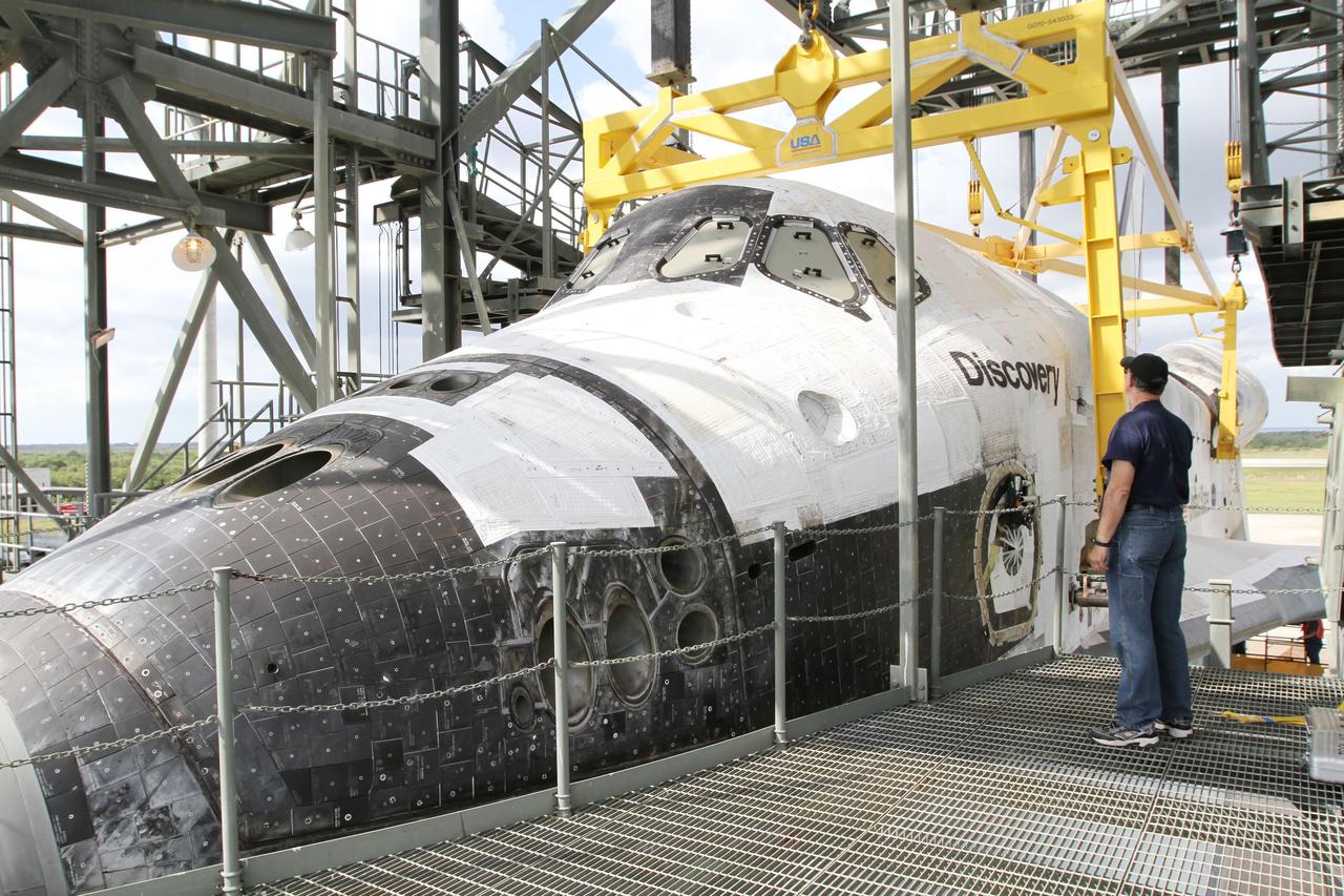 CAPE CANAVERAL, Fla. – At the Shuttle Landing Facility at NASA’s Kennedy Space Center in Florida, a worker inspects space shuttle Discovery as it is attached to the Shuttle Carrier Aircraft in the mate-demate device.    The device, known as the MDD, is a large gantry-like steel structure used to hoist a shuttle off the ground and position it onto the back of the aircraft, or SCA. The SCA is a Boeing 747 jet, originally manufactured for commercial use, which was modified by NASA to transport the shuttles between destinations on Earth. The SCA designated NASA 905 is assigned to the remaining ferry missions, delivering the shuttles to their permanent public display sites.  NASA 905 is scheduled to ferry Discovery to the Washington Dulles International Airport in Virginia on April 17, after which the shuttle will be placed on display in the Smithsonian's National Air and Space Museum Steven F. Udvar-Hazy Center. For more information on the SCA, visit http://www.nasa.gov/centers/dryden/news/FactSheets/FS-013-DFRC.html. For more information on shuttle transition and retirement activities, visit http://www.nasa.gov/transition. Photo credit: NASA/Kim Shiflett