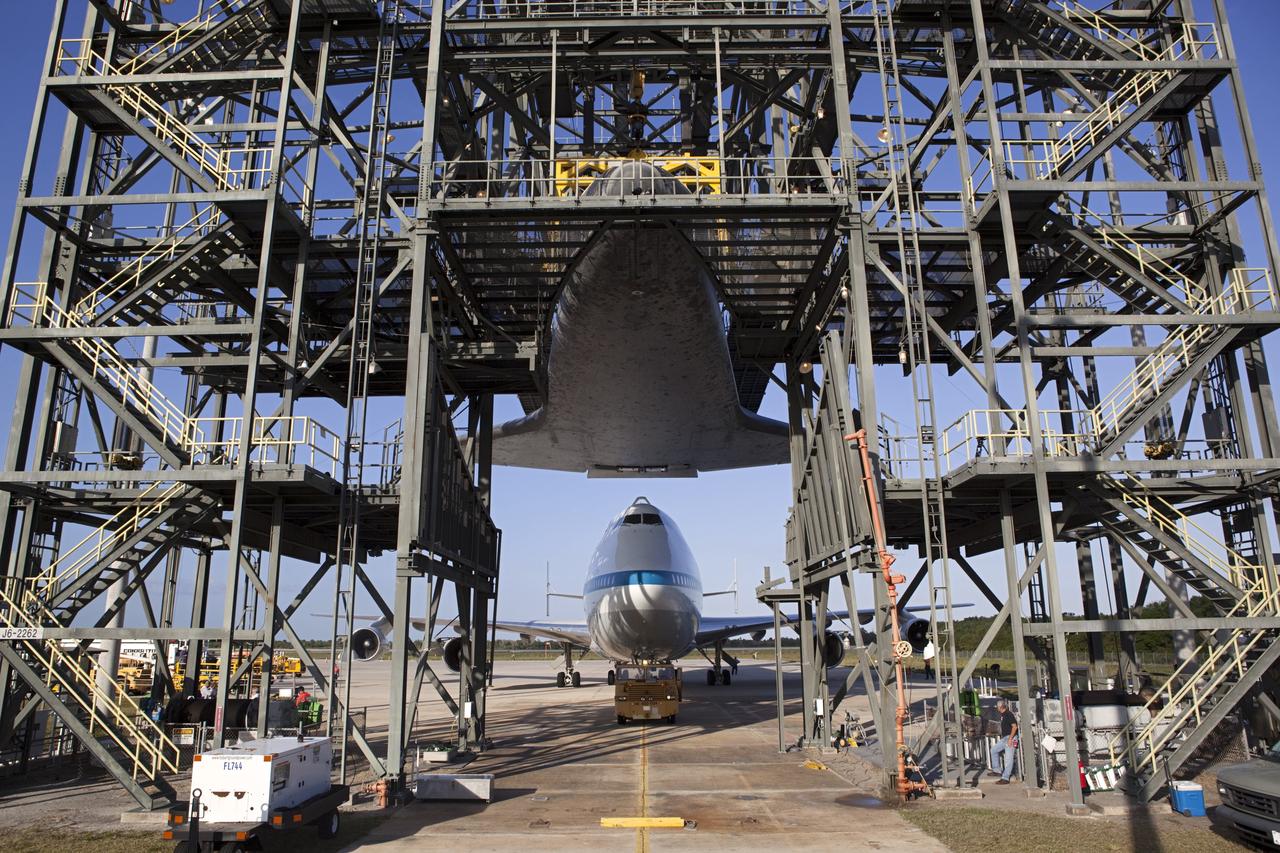 CAPE CANAVERAL, Fla. – At the Shuttle Landing Facility at NASA’s Kennedy Space Center in Florida, the Shuttle Carrier Aircraft moves into position under space shuttle Discovery suspended 60 feet off the ground in the mate-demate device.      The device, known as the MDD, is a large gantry-like steel structure used to hoist a shuttle off the ground and position it onto the back of the aircraft, or SCA. The SCA is a Boeing 747 jet, originally manufactured for commercial use, which was modified by NASA to transport the shuttles between destinations on Earth. This SCA, designated NASA 905, is assigned to the remaining ferry missions, delivering the shuttles to their permanent public display sites.  NASA 905 is scheduled to ferry Discovery to the Washington Dulles International Airport in Virginia on April 17, after which the shuttle will be placed on display in the Smithsonian's National Air and Space Museum Steven F. Udvar-Hazy Center. For more information on the SCA, visit http://www.nasa.gov/centers/dryden/news/FactSheets/FS-013-DFRC.html. For more information on shuttle transition and retirement activities, visit http://www.nasa.gov/transition. Photo credit: NASA/Dimitri Gerondidakis