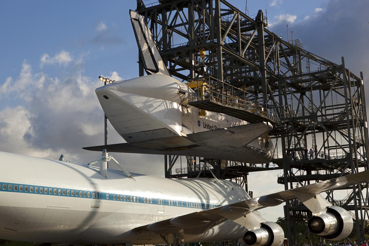 CAPE CANAVERAL, Fla. – At the Shuttle Landing Facility at NASA’s Kennedy Space Center in Florida, the Shuttle Carrier Aircraft moves into position under space shuttle Discovery suspended 60 feet off the ground in the mate-demate device.      The device, known as the MDD, is a large gantry-like steel structure used to hoist a shuttle off the ground and position it onto the back of the aircraft, or SCA. The SCA is a Boeing 747 jet, originally manufactured for commercial use, which was modified by NASA to transport the shuttles between destinations on Earth. This SCA, designated NASA 905, is assigned to the remaining ferry missions, delivering the shuttles to their permanent public display sites.  NASA 905 is scheduled to ferry Discovery to the Washington Dulles International Airport in Virginia on April 17, after which the shuttle will be placed on display in the Smithsonian's National Air and Space Museum Steven F. Udvar-Hazy Center. For more information on the SCA, visit http://www.nasa.gov/centers/dryden/news/FactSheets/FS-013-DFRC.html. For more information on shuttle transition and retirement activities, visit http://www.nasa.gov/transition. Photo credit: NASA/Dimitri Gerondidakis