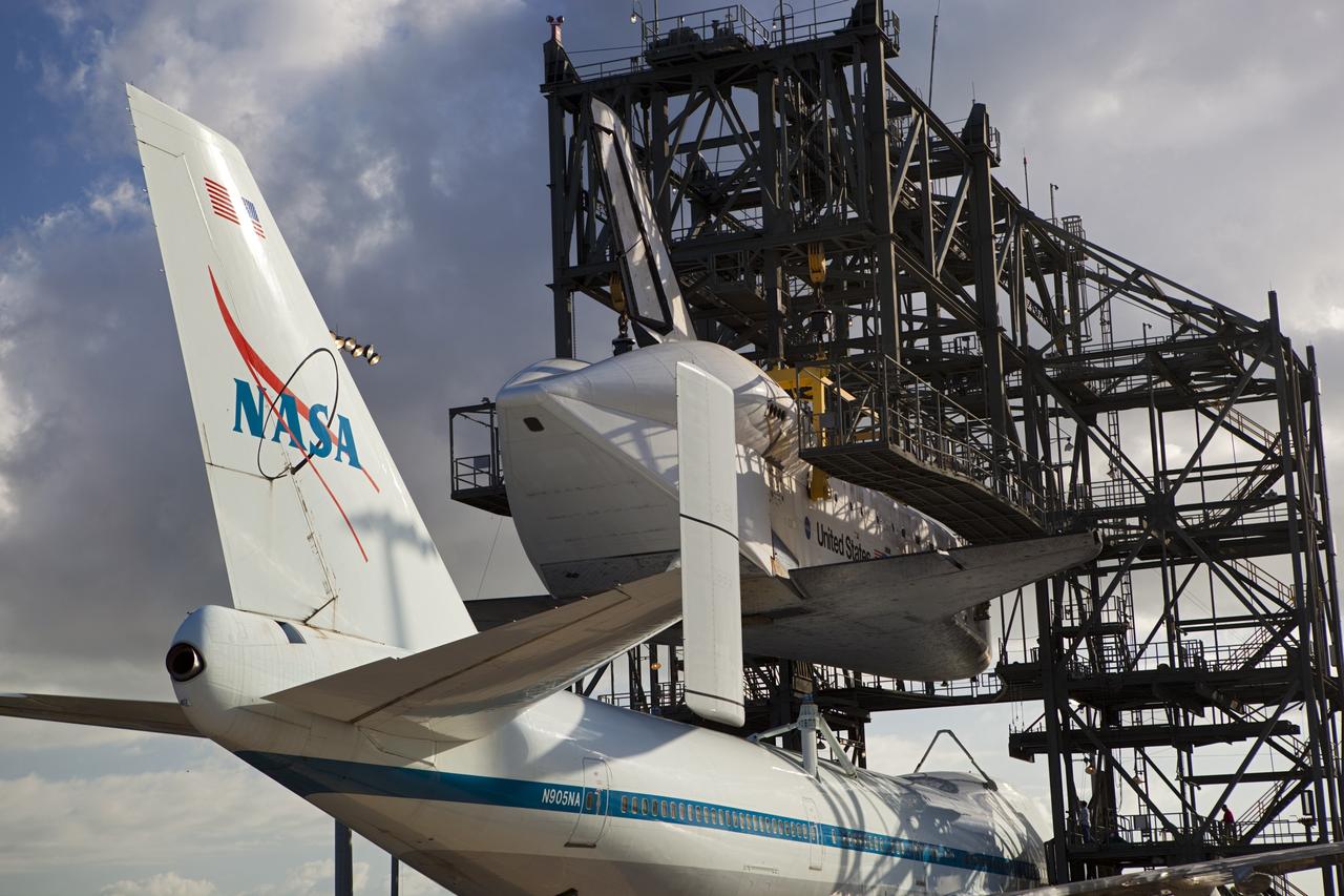 CAPE CANAVERAL, Fla. – At the Shuttle Landing Facility at NASA’s Kennedy Space Center in Florida, the Shuttle Carrier Aircraft moves into position under space shuttle Discovery suspended 60 feet off the ground in the mate-demate device.      The device, known as the MDD, is a large gantry-like steel structure used to hoist a shuttle off the ground and position it onto the back of the aircraft, or SCA. The SCA is a Boeing 747 jet, originally manufactured for commercial use, which was modified by NASA to transport the shuttles between destinations on Earth. This SCA, designated NASA 905, is assigned to the remaining ferry missions, delivering the shuttles to their permanent public display sites.  NASA 905 is scheduled to ferry Discovery to the Washington Dulles International Airport in Virginia on April 17, after which the shuttle will be placed on display in the Smithsonian's National Air and Space Museum Steven F. Udvar-Hazy Center. For more information on the SCA, visit http://www.nasa.gov/centers/dryden/news/FactSheets/FS-013-DFRC.html. For more information on shuttle transition and retirement activities, visit http://www.nasa.gov/transition. Photo credit: NASA/Dimitri Gerondidakis