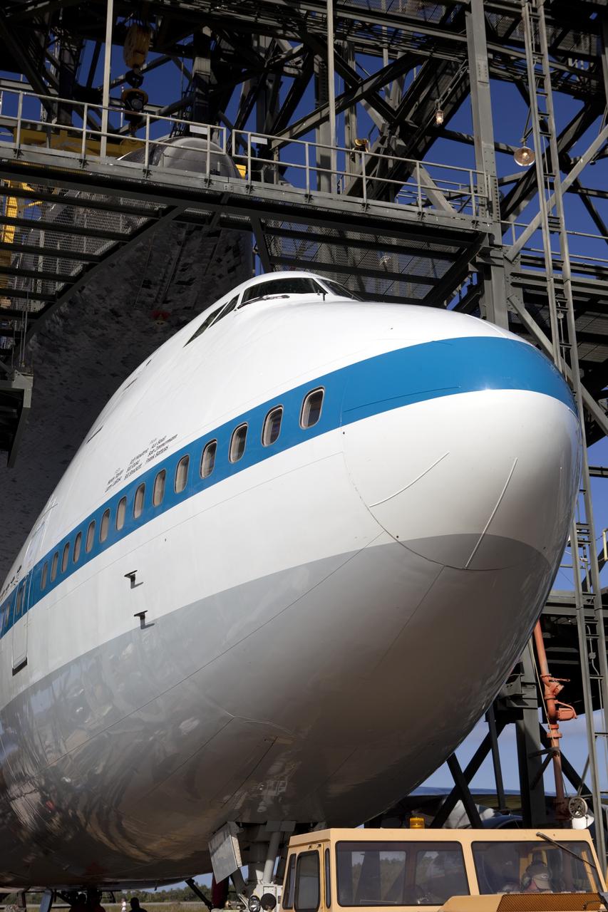 CAPE CANAVERAL, Fla. – At the Shuttle Landing Facility at NASA’s Kennedy Space Center in Florida, the Shuttle Carrier Aircraft is in position under space shuttle Discovery in the mate-demate device for mating operations to begin.     The device, known as the MDD, is a large gantry-like steel structure used to hoist a shuttle off the ground and position it onto the back of the aircraft, or SCA. The SCA is a Boeing 747 jet, originally manufactured for commercial use, which was modified by NASA to transport the shuttles between destinations on Earth. This SCA, designated NASA 905, is assigned to the remaining ferry missions, delivering the shuttles to their permanent public display sites.  NASA 905 is scheduled to ferry Discovery to the Washington Dulles International Airport in Virginia on April 17, after which the shuttle will be placed on display in the Smithsonian's National Air and Space Museum Steven F. Udvar-Hazy Center. For more information on the SCA, visit http://www.nasa.gov/centers/dryden/news/FactSheets/FS-013-DFRC.html. For more information on shuttle transition and retirement activities, visit http://www.nasa.gov/transition. Photo credit: NASA/Dimitri Gerondidakis