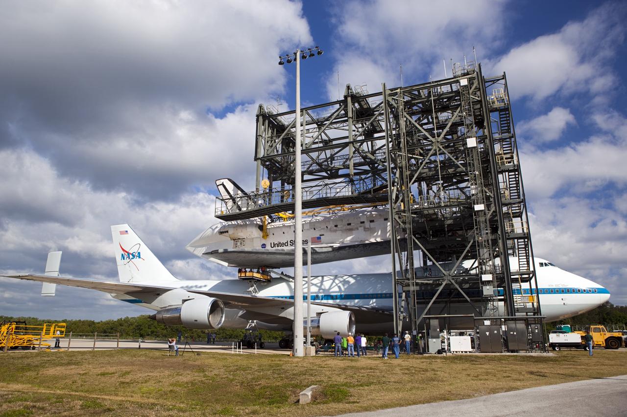 CAPE CANAVERAL, Fla. – At the Shuttle Landing Facility at NASA’s Kennedy Space Center in Florida, workers attach space shuttle Discovery to the Shuttle Carrier Aircraft in the mate-demate device.    The device, known as the MDD, is a large gantry-like steel structure used to hoist a shuttle off the ground and position it onto the back of the aircraft, or SCA. The SCA is a Boeing 747 jet, originally manufactured for commercial use, which was modified by NASA to transport the shuttles between destinations on Earth. This SCA, designated NASA 905, is assigned to the remaining ferry missions, delivering the shuttles to their permanent public display sites.  NASA 905 is scheduled to ferry Discovery to the Washington Dulles International Airport in Virginia on April 17, after which the shuttle will be placed on display in the Smithsonian's National Air and Space Museum Steven F. Udvar-Hazy Center. For more information on the SCA, visit http://www.nasa.gov/centers/dryden/news/FactSheets/FS-013-DFRC.html. For more information on shuttle transition and retirement activities, visit http://www.nasa.gov/transition. Photo credit: NASA/Dimitri Gerondidakis