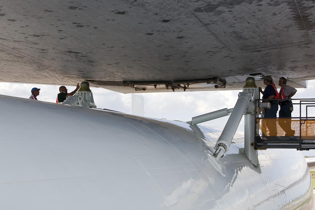 CAPE CANAVERAL, Fla. – At the Shuttle Landing Facility at NASA’s Kennedy Space Center in Florida, workers in the mate-demate device attach space shuttle Discovery to the Shuttle Carrier Aircraft.    The device, known as the MDD, is a large gantry-like steel structure used to hoist a shuttle off the ground and position it onto the back of the aircraft, or SCA. The SCA is a Boeing 747 jet, originally manufactured for commercial use, which was modified by NASA to transport the shuttles between destinations on Earth. This SCA, designated NASA 905, is assigned to the remaining ferry missions, delivering the shuttles to their permanent public display sites.  NASA 905 is scheduled to ferry Discovery to the Washington Dulles International Airport in Virginia on April 17, after which the shuttle will be placed on display in the Smithsonian's National Air and Space Museum Steven F. Udvar-Hazy Center. For more information on the SCA, visit http://www.nasa.gov/centers/dryden/news/FactSheets/FS-013-DFRC.html. For more information on shuttle transition and retirement activities, visit http://www.nasa.gov/transition. Photo credit: NASA/Dimitri Gerondidakis
