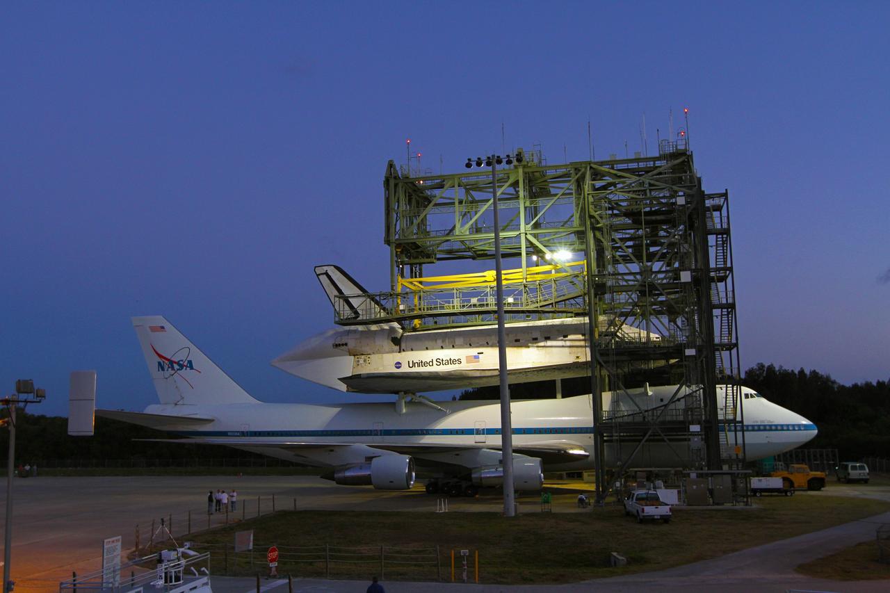 CAPE CANAVERAL, Fla. – Preparations are under way just before sunrise for the Shuttle Carrier Aircraft carrying space shuttle Discovery to back out of the Shuttle Landing Facility's mate-demate device at NASA’s Kennedy Space Center in Florida. The device, known as the MDD, is a large gantry-like steel structure used to hoist a shuttle off the ground and position it onto the back of the aircraft, or SCA. The SCA is a Boeing 747 jet that was originally manufactured for commercial use and modified by NASA to transport the shuttles between destinations on Earth. This SCA, designated NASA 905, is assigned to the remaining ferry missions, delivering the shuttles to their permanent public display sites. NASA 905 is scheduled to ferry Discovery to the Washington Dulles International Airport in Virginia on April 17, after which the shuttle will be placed on display in the Smithsonian's National Air and Space Museum Steven F. Udvar-Hazy Center. For more information on the SCA, visit http://www.nasa.gov/centers/dryden/news/FactSheets/FS-013-DFRC.html. For more information on shuttle transition and retirement activities, visit http://www.nasa.gov/transition. Photo credit: NASA/Kim Shiflett