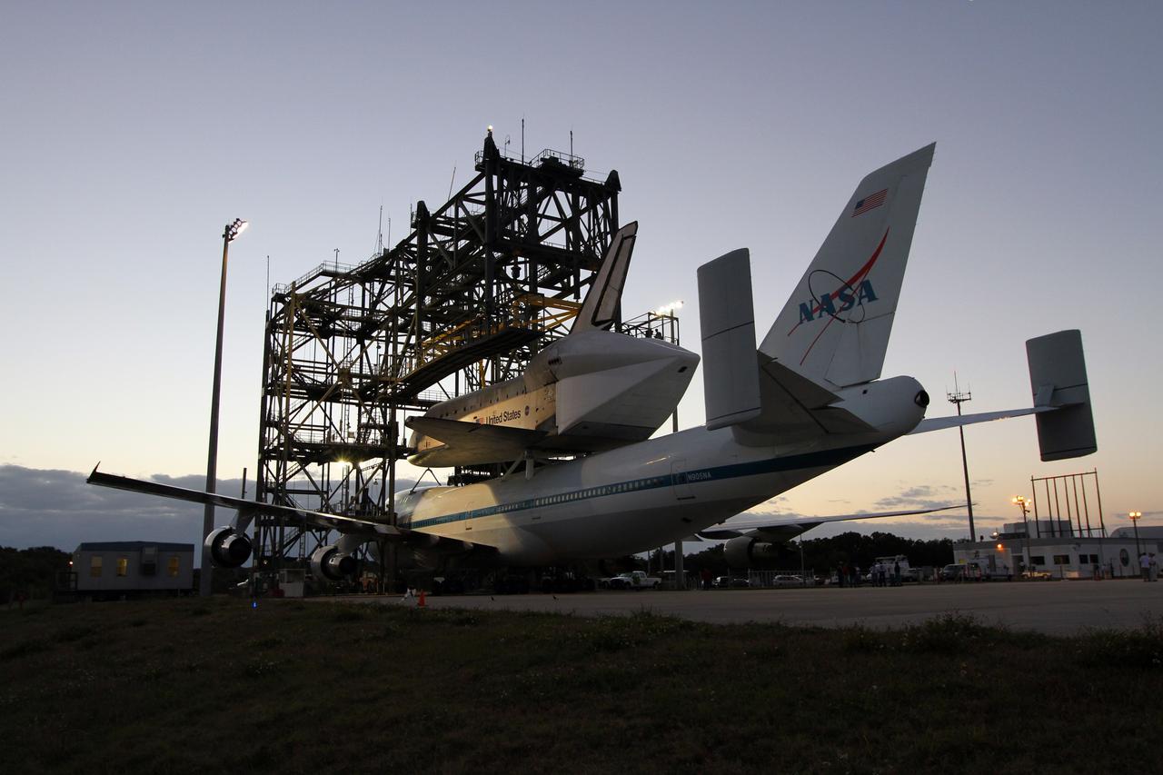 CAPE CANAVERAL, Fla. – As the sun rises, preparations are under way for the Shuttle Carrier Aircraft carrying space shuttle Discovery to back out of the Shuttle Landing Facility's mate-demate device at NASA’s Kennedy Space Center in Florida. The device, known as the MDD, is a large gantry-like steel structure used to hoist a shuttle off the ground and position it onto the back of the aircraft, or SCA. The SCA is a Boeing 747 jet that was originally manufactured for commercial use and modified by NASA to transport the shuttles between destinations on Earth. This SCA, designated NASA 905, is assigned to the remaining ferry missions, delivering the shuttles to their permanent public display sites. NASA 905 is scheduled to ferry Discovery to the Washington Dulles International Airport in Virginia on April 17, after which the shuttle will be placed on display in the Smithsonian's National Air and Space Museum Steven F. Udvar-Hazy Center. For more information on the SCA, visit http://www.nasa.gov/centers/dryden/news/FactSheets/FS-013-DFRC.html. For more information on shuttle transition and retirement activities, visit http://www.nasa.gov/transition. Photo credit: NASA/Kim Shiflett