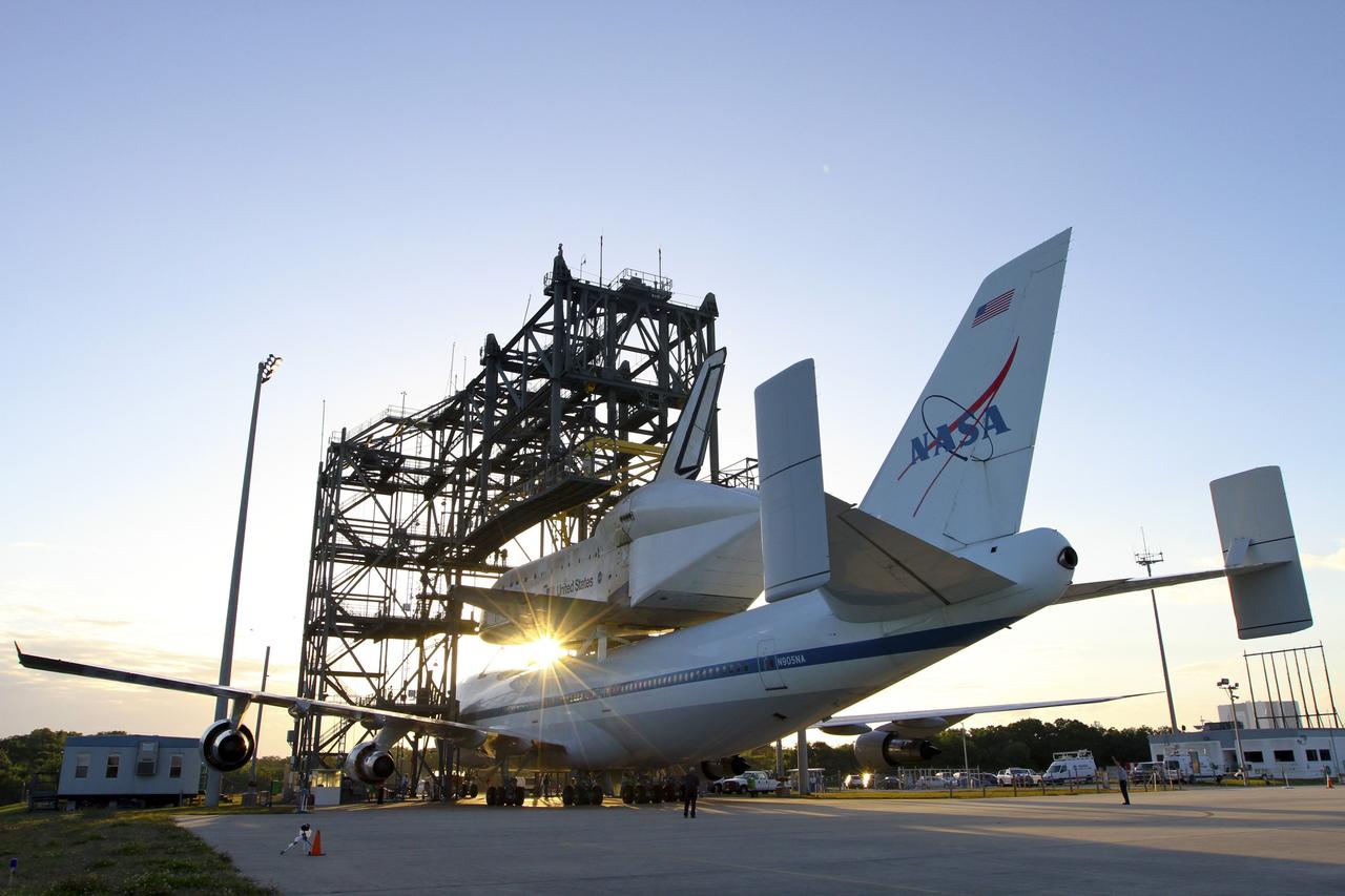 CAPE CANAVERAL, Fla. – The Shuttle Carrier Aircraft carrying space shuttle Discovery backs out of the Shuttle Landing Facility's mate-demate device at NASA’s Kennedy Space Center in Florida. The device, known as the MDD, is a large gantry-like steel structure used to hoist a shuttle off the ground and position it onto the back of the aircraft, or SCA. The SCA is a Boeing 747 jet that was originally manufactured for commercial use and modified by NASA to transport the shuttles between destinations on Earth. This SCA, designated NASA 905, is assigned to the remaining ferry missions, delivering the shuttles to their permanent public display sites. NASA 905 is scheduled to ferry Discovery to the Washington Dulles International Airport in Virginia on April 17, after which the shuttle will be placed on display in the Smithsonian's National Air and Space Museum Steven F. Udvar-Hazy Center. For more information on the SCA, visit http://www.nasa.gov/centers/dryden/news/FactSheets/FS-013-DFRC.html. For more information on shuttle transition and retirement activities, visit http://www.nasa.gov/transition. Photo credit: NASA/Kim Shiflett