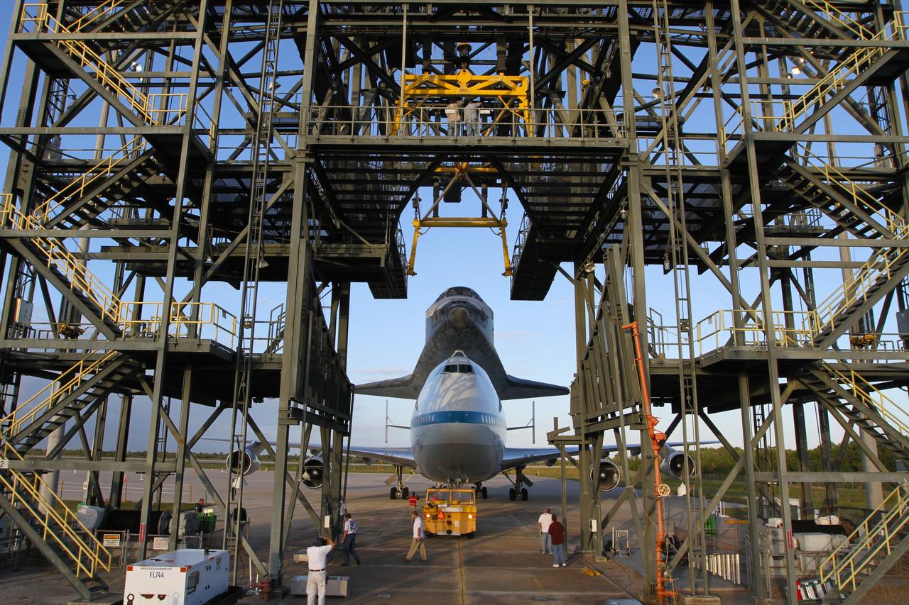 CAPE CANAVERAL, Fla. – The Shuttle Carrier Aircraft carrying space shuttle Discovery backs out of the Shuttle Landing Facility's mate-demate device at NASA’s Kennedy Space Center in Florida. The device, known as the MDD, is a large gantry-like steel structure used to hoist a shuttle off the ground and position it onto the back of the aircraft, or SCA. The SCA is a Boeing 747 jet that was originally manufactured for commercial use and modified by NASA to transport the shuttles between destinations on Earth. This SCA, designated NASA 905, is assigned to the remaining ferry missions, delivering the shuttles to their permanent public display sites. NASA 905 is scheduled to ferry Discovery to the Washington Dulles International Airport in Virginia on April 17, after which the shuttle will be placed on display in the Smithsonian's National Air and Space Museum Steven F. Udvar-Hazy Center. For more information on the SCA, visit http://www.nasa.gov/centers/dryden/news/FactSheets/FS-013-DFRC.html. For more information on shuttle transition and retirement activities, visit http://www.nasa.gov/transition. Photo credit: NASA/Kim Shiflett
