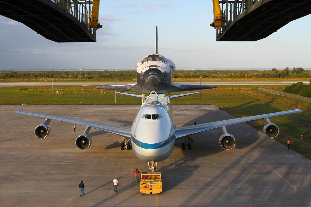 CAPE CANAVERAL, Fla. – The Shuttle Carrier Aircraft carrying space shuttle Discovery backs out of the Shuttle Landing Facility's mate-demate device at NASA’s Kennedy Space Center in Florida. The device, known as the MDD, is a large gantry-like steel structure used to hoist a shuttle off the ground and position it onto the back of the aircraft, or SCA. The SCA is a Boeing 747 jet that was originally manufactured for commercial use and modified by NASA to transport the shuttles between destinations on Earth. This SCA, designated NASA 905, is assigned to the remaining ferry missions, delivering the shuttles to their permanent public display sites. NASA 905 is scheduled to ferry Discovery to the Washington Dulles International Airport in Virginia on April 17, after which the shuttle will be placed on display in the Smithsonian's National Air and Space Museum Steven F. Udvar-Hazy Center. For more information on the SCA, visit http://www.nasa.gov/centers/dryden/news/FactSheets/FS-013-DFRC.html. For more information on shuttle transition and retirement activities, visit http://www.nasa.gov/transition. Photo credit: NASA/Kim Shiflett