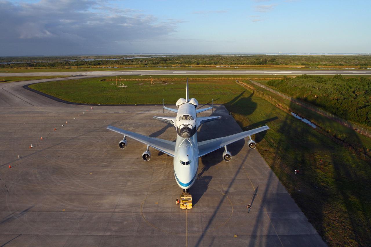 CAPE CANAVERAL, Fla. – The Shuttle Carrier Aircraft carrying space shuttle Discovery is on the ramp of the Shuttle Landing Facility at NASA’s Kennedy Space Center in Florida. Earlier, the duo backed out of the mate-demate device. Known as the MDD, the device is a large gantry-like steel structure used to hoist a shuttle off the ground and position it onto the back of the aircraft, or SCA. The SCA is a Boeing 747 jet that was originally manufactured for commercial use and modified by NASA to transport the shuttles between destinations on Earth. This SCA, designated NASA 905, is assigned to the remaining ferry missions, delivering the shuttles to their permanent public display sites. NASA 905 is scheduled to ferry Discovery to the Washington Dulles International Airport in Virginia on April 17, after which the shuttle will be placed on display in the Smithsonian's National Air and Space Museum Steven F. Udvar-Hazy Center. For more information on the SCA, visit http://www.nasa.gov/centers/dryden/news/FactSheets/FS-013-DFRC.html. For more information on shuttle transition and retirement activities, visit http://www.nasa.gov/transition. Photo credit: NASA/Kim Shiflett
