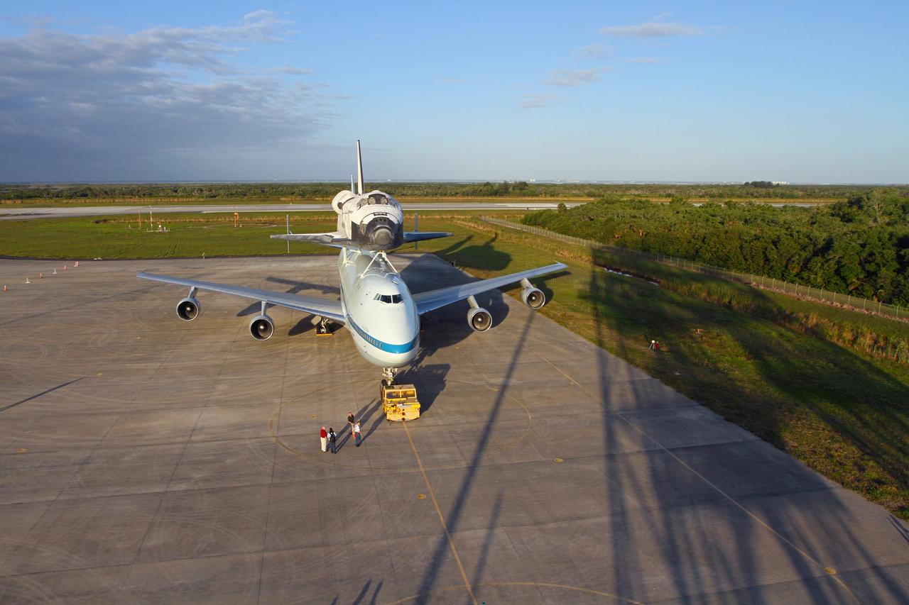 CAPE CANAVERAL, Fla. – The Shuttle Carrier Aircraft carrying space shuttle Discovery is on the ramp of the Shuttle Landing Facility at NASA’s Kennedy Space Center in Florida. Earlier, the duo backed out of the mate-demate device. Known as the MDD, the device is a large gantry-like steel structure used to hoist a shuttle off the ground and position it onto the back of the aircraft, or SCA. The SCA is a Boeing 747 jet that was originally manufactured for commercial use and modified by NASA to transport the shuttles between destinations on Earth. This SCA, designated NASA 905, is assigned to the remaining ferry missions, delivering the shuttles to their permanent public display sites.         NASA 905 is scheduled to ferry Discovery to the Washington Dulles International Airport in Virginia on April 17, after which the shuttle will be placed on display in the Smithsonian's National Air and Space Museum Steven F. Udvar-Hazy Center. For more information on the SCA, visit http://www.nasa.gov/centers/dryden/news/FactSheets/FS-013-DFRC.html. For more information on shuttle transition and retirement activities, visit http://www.nasa.gov/transition. Photo credit: NASA/Kim Shiflett